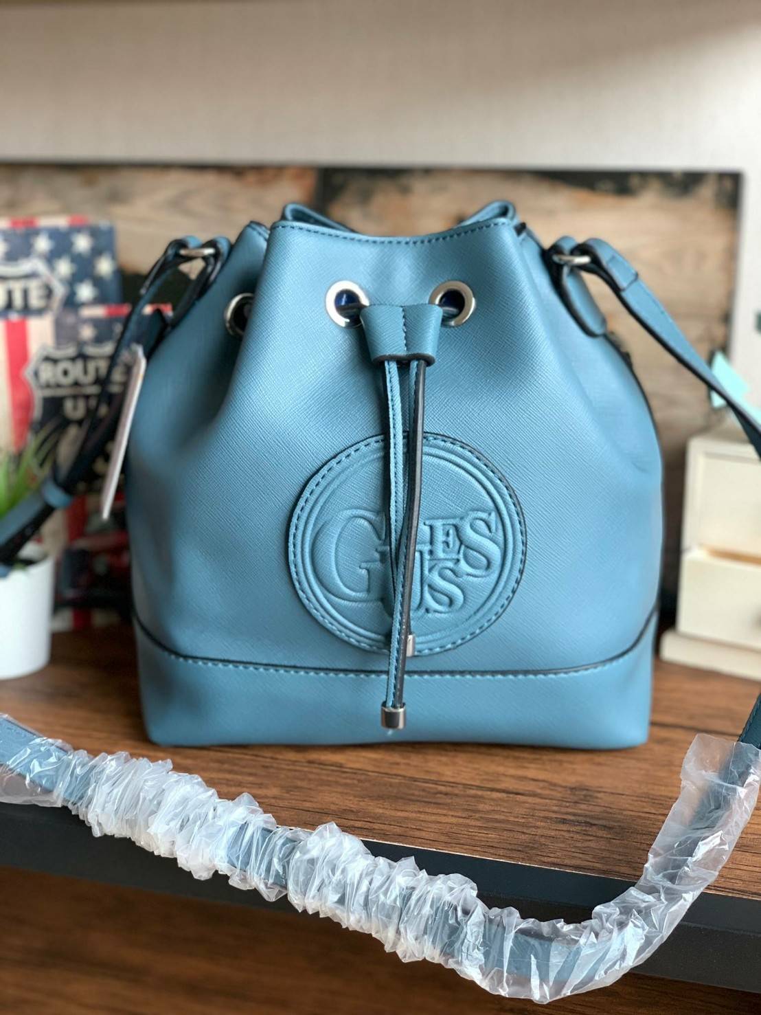 Guess Drawstring Bucket Bag กระเป๋าสะพายขนาดกลาง วัสดุลายหนังsaffiano ฐานกว้างตั้งอยู่ทรง มีซิกเนเจอร์ที่ด้านหน้าเป็นโลโก้ตัวนูน เปิดปิดแบบหูรูดและกระดุมแม่เหล็ก มีช่องใช้งานหลายข่อง สายสะพายปรับได้แบบเข็มขัด สวยแบบมีดีเทลเก๋ๆ สะพายเที่ยวระหว่างวันได้สบาย