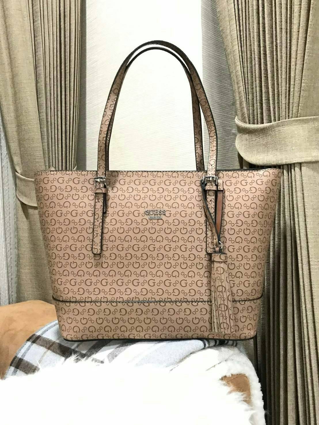 GUESS SINGNATURE SHOPPER BAG (SIZE L) กระเป๋าสะพายรุ่นใหม่ล่าสุดจาก GUESS FACTORY หนังสวยอยู่ทรงปั้มลาย Singnature Brand รอบใบ ด้านหน้าประดับโลโก้แบรนด์ ด้านหลังมีช่องใส่ของ หูหิ้วสะพายไหล่ได้สามารถเลื่อนปรับระดับได้ พร้อมประดับพู่หนังห้อยที่หูกระเป๋าดูมี