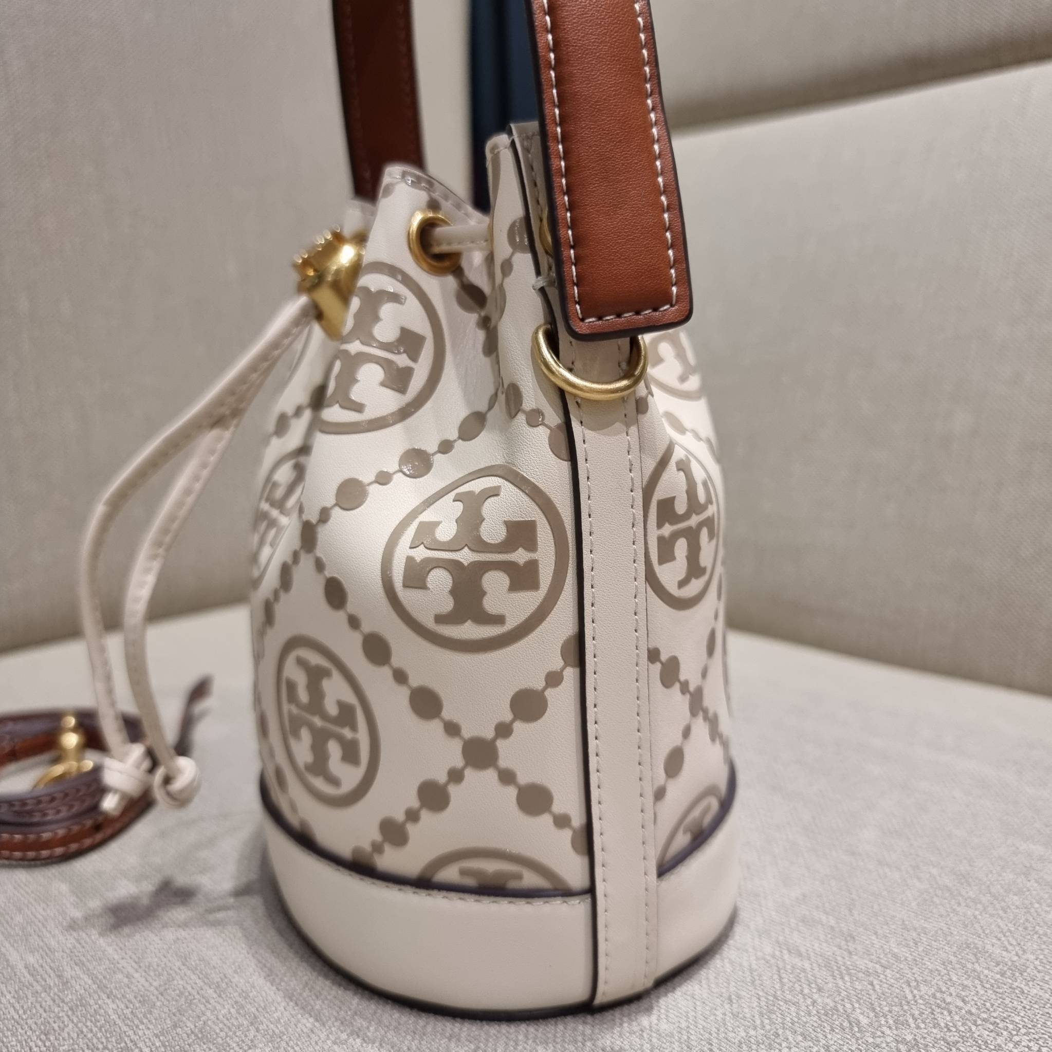 TORY BURCH T MONOGRAM EMBOSSED MINI BUCKET BAG คอลเลคชั่นใหม่ กับกระเป๋าบัคเก็ตทรงยอดนิยม ในไซส์มินิ ดีไซน์ใหม่ล่าสุด สวยลูกคุณหนู หรูหรา!! ด้วยดีเทลผิวลายนูนลวดลายเอกลักษณ์ วัสดุหนังแท้ ปากกระเป๋ารูดเปิด-ปิดได้ มีหูจับในตัว สะดวกใช้ไปอีก และมีสายสะพายข้า