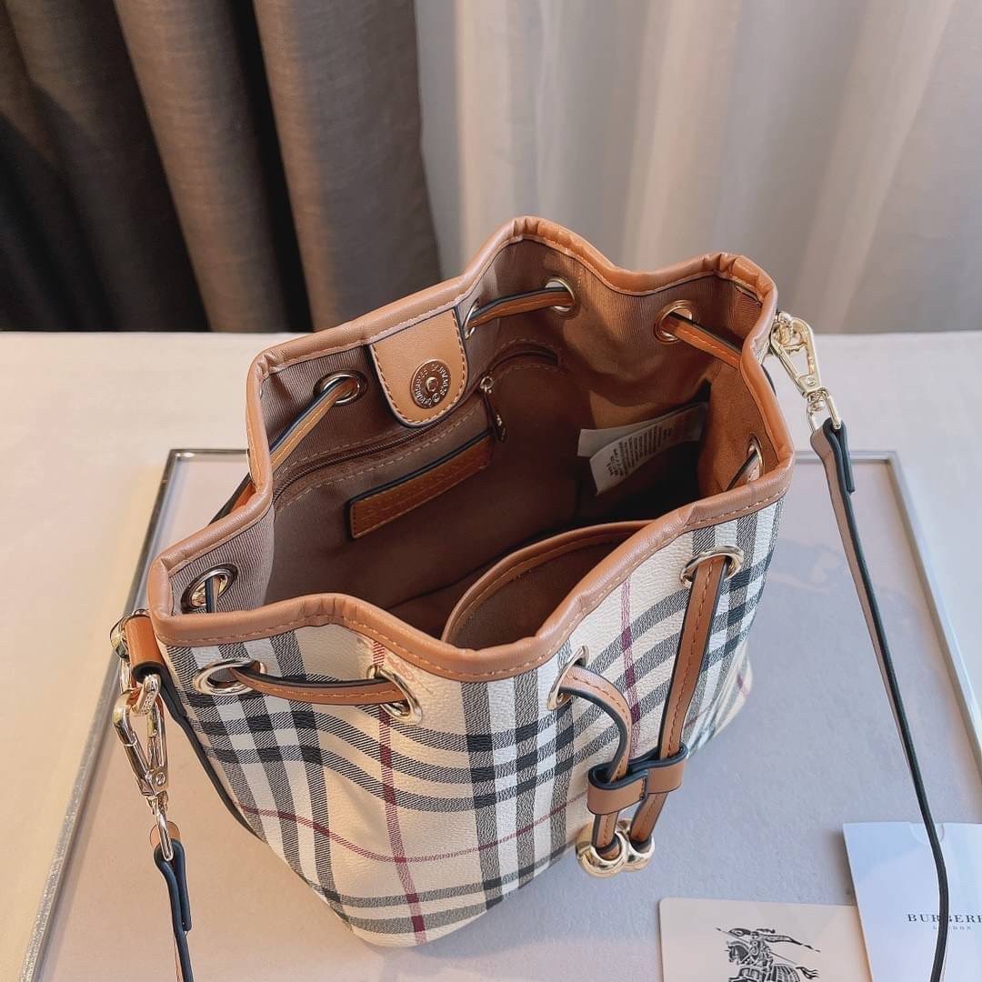 BURBERRY MINI BUCKET VINTAGE LEATHER BAG งานพรีเมียมกิ้ฟท์เคาเตอร์ น้ำหอมจากแบรนด์ วัสดุหนัง PVC ทรงขนมจีบสุดคิ้วท์ เนื้อหนาซับในอย่างดี กระเป๋าสามารถ จุของได้เยอะมาก ด้านในมีช่องซิปพร้อมช่องใส่ของอีกหนึ่งช่อง ถือแล้วสวยมากๆ จุของได้กำลังดี ทรงนี้ต้องมีติ
