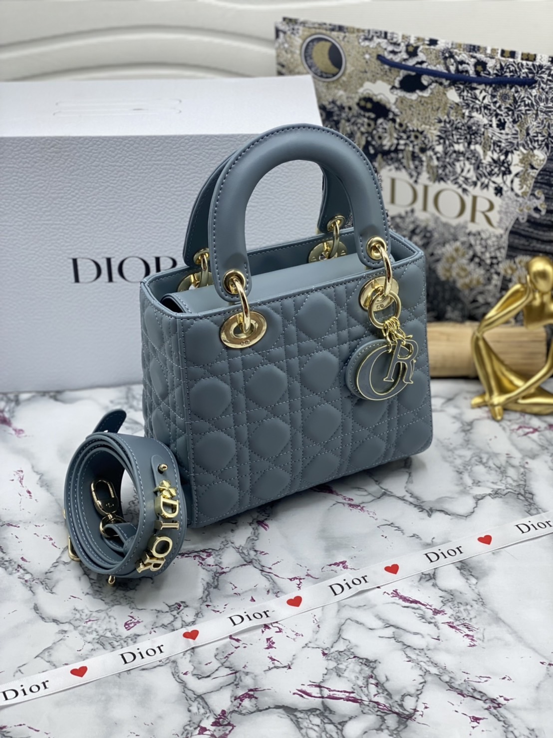หนังแท้ DIOR LADY BAG 20cm ความสง่างามอีกหนึ่งรุ่นของ Dior รูปทรงสีเหลียม ขนาดกระทัดรัด ตั้งอยู่ทรง ฐานกระเป๋าแข็งแรง มีหมุดรองฐาน ดีไซน์ที่มีเอกลักษณ์เฉพาะตัว ด้านหน้าตกแต่งด้วยตัวอักษร D.I.R ห้อยเป็นพวงกุญแจ จะถือด้วยมือหรือสะพายไหล่ก็ดูดีมากๆ ค่ะ