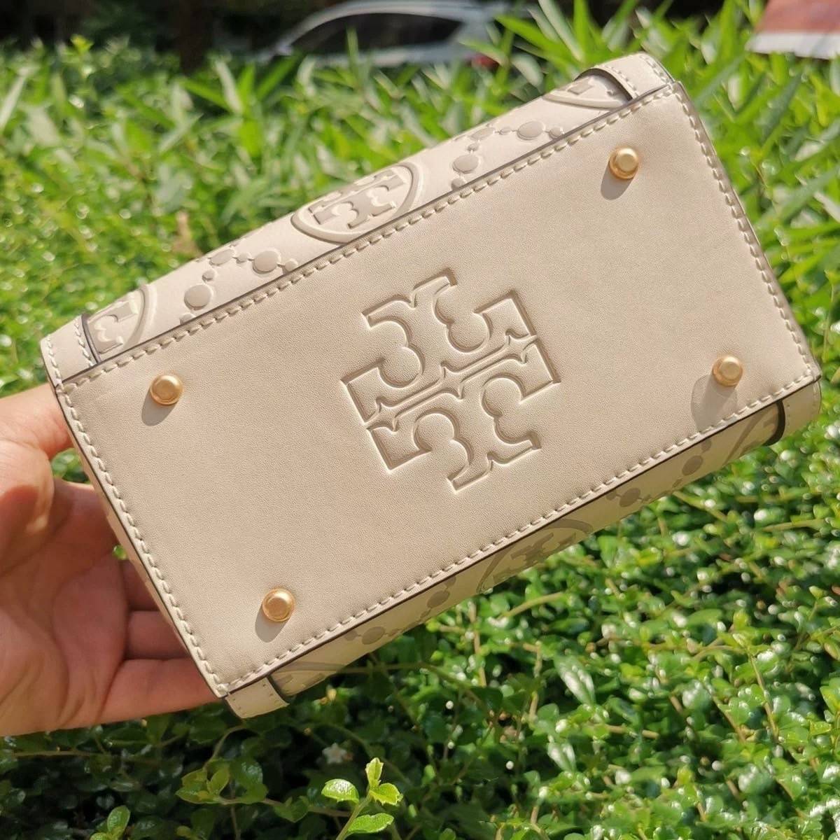 Tory Burch T-Monogram Mini Embossed Wine Bucket Bag / Tory Burch Mini Bucket กระเป๋าถือหรือสะพายไหล่ ทรงหมอนขนาดเล็ก ประดับด้วยลวดลายอันเป็นสัญลักษณ์ของแบรนด์ ถูกประดิษขึ้นด้วยความพิถีพิถันวัสดุหนังอย่างดี ด้านในบุด้วยหนังไมโครซูแอคเนื้อนุ่มทำความสะอาดง่า