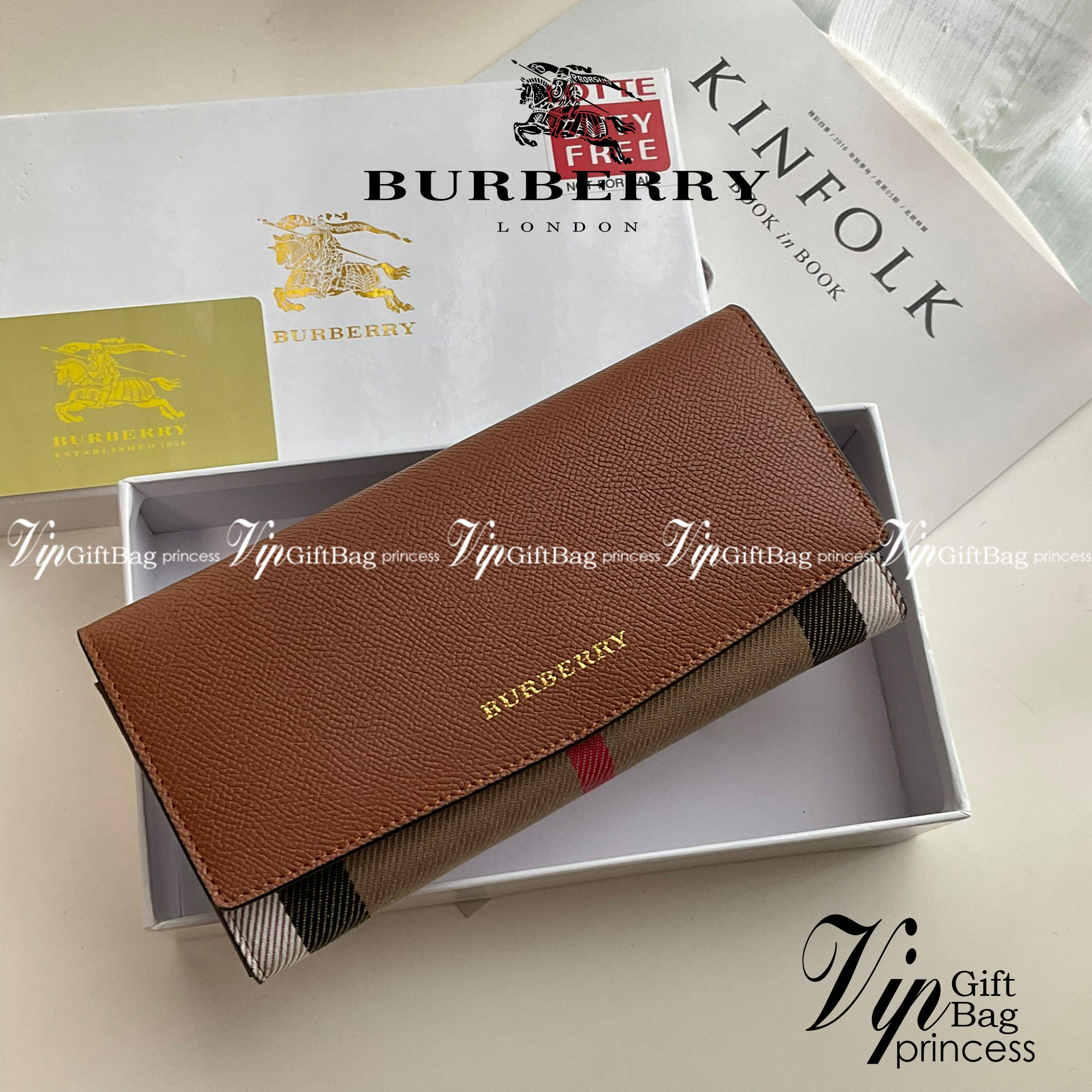 กระเป๋าสตางค์รับทรัพย์ ทรงหรู จากงาพรีเมี่ยมกิ๊ฟ Limited Edition จาก BURBERRY กระเป๋าสตางค์ใบยาวแบบพับกระดุม ทูโทนด้วยหนังแท้คาดผ้าลาย vintage ด้านในมีช่องใส่ธนบัตรยาวทั้งสองฝั่ง ช่องใส่บัตรได้อย่างน้อย 12 ช่อง และช่องเปิดด้วยซิปปั้มแบรนด์อะไหล่ทองสุดหรู 