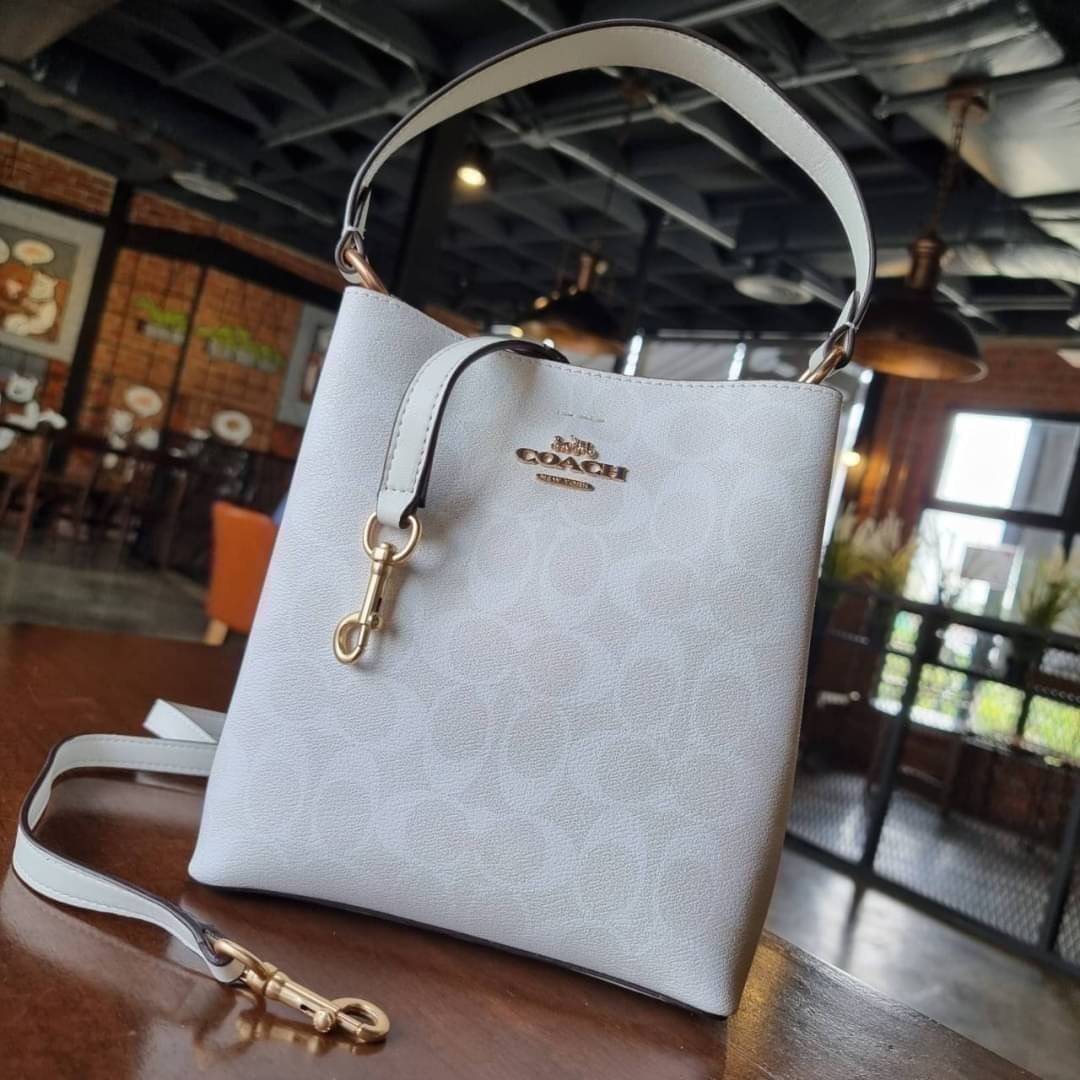 COACH 2312 SMALL TOWN BUCKET BAG IN SIGNATURE CANVAS รุ่นยอดนิยมใบเล็กมาครบสีแล้วจ้า กระเป๋าทรงบัคเก็ต สีผู้ดี๊ผู้ดี ตัวกระเป๋าดีไซน์คลาสสิคลายซี ดูโดดเด่น วัสดุหนังแคนวาสเคลือบลาย สวยคมทุกมุมจริงๆ!! เปิด-ปิดด้วยกระดุมแม่เหล็กทั้ง 2 ฝั่ง ภายในเป็นช่องโล่ง