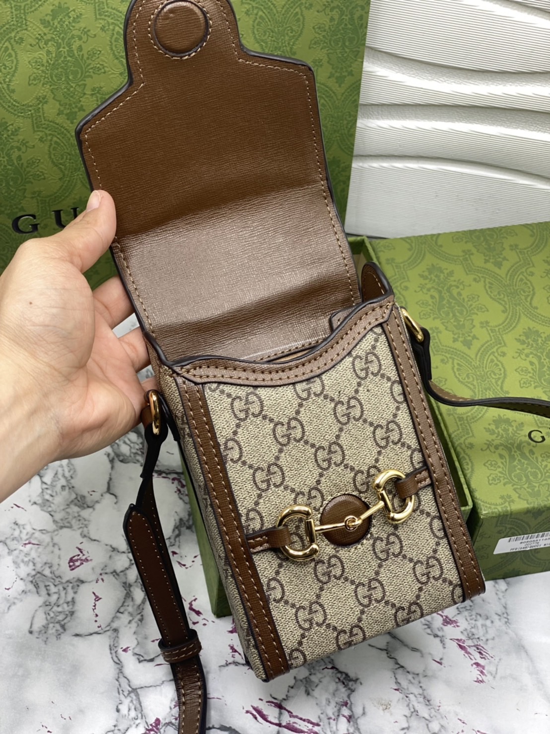 หนังแท้ GUCCI Horsebit phone bag กระเป๋าสะพาย กระเป๋าใส่โทรศัพท์สุดคลาสสิก หนังวัวแท้สีน้ำตาล/สีขาว อะไหล่ทองสวย ดีไซต์สัญลักษณ์วงแหวนตามแบบฉบับแบรนด์ สายสะพายยาวที่สามารถปรับระดับได้ ภาพสินค้าถ่ายจากงานขายจริง ใช้งานต่างประเทศได้ค่ะ