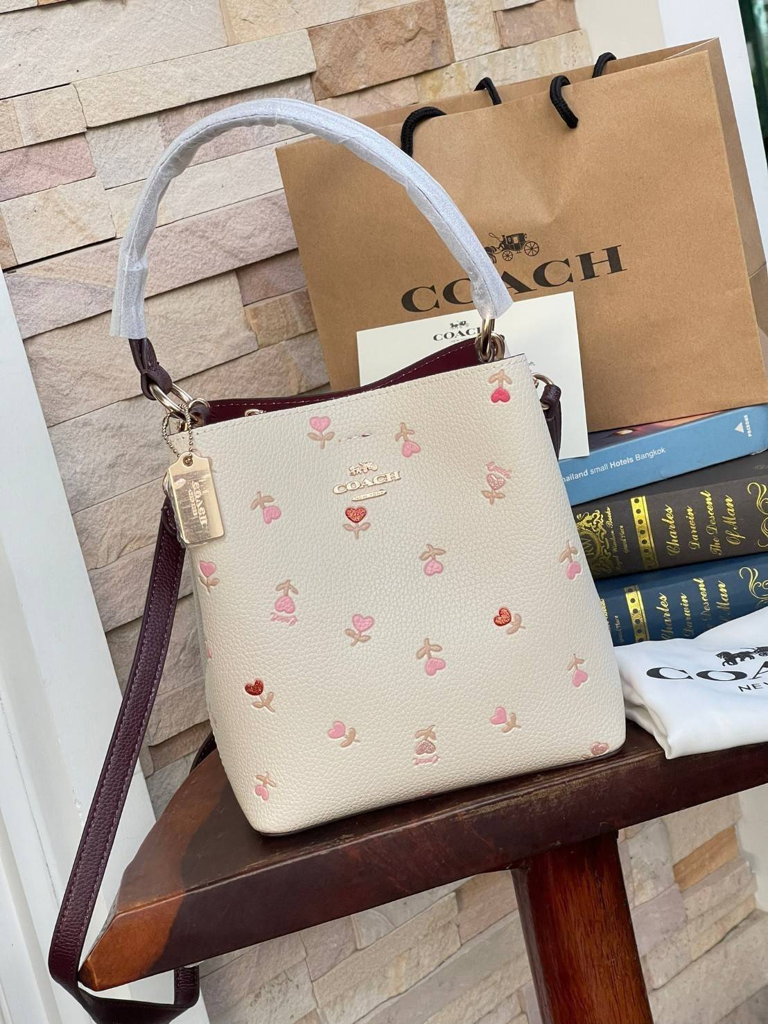 OUTTLET 】COACH SMALL TOWN BUCKET BAG IN SIGNATURE WITH Heart floral print สำหรับสาวแฟชั่นที่ชอบรายละเอียดชิคๆ ดีไซน์สุดเก๋ แนะนำเลยสำหรับกระเป๋าทรงบักเก็ตใบนี้ เชื่อว่าสาว ๆ หลายคนชื่นชอบ เป็นไอเทมที่สามารถแมทช์ได้กับเสื้อหลากหลายสไตล์ บรรจุของได้เยอะโดยท