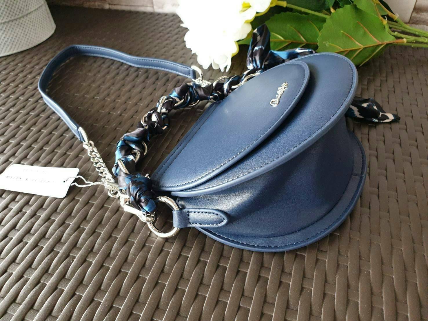 CHARLES & KEITH รุ่น LEATHER SATIN SCARF CROSSBODY BAG SL2-50150828 ราคาปกติช้อป ( ฿3,590.00 ) กระเป๋าถือ และ สะพาย ทรงโค้งมน หนังเรียบ ตั้งอยู่ทรง ด้านหน้าติดโลโก้แบรนด์ อะไหล่เงิน หูจับสายกระเป๋าร้อยเข้ากับห่วงเหล็กกลมๆ ด้วยผ้าลายสวยงามผูกเป็นโบว์เก๋ๆ ถ