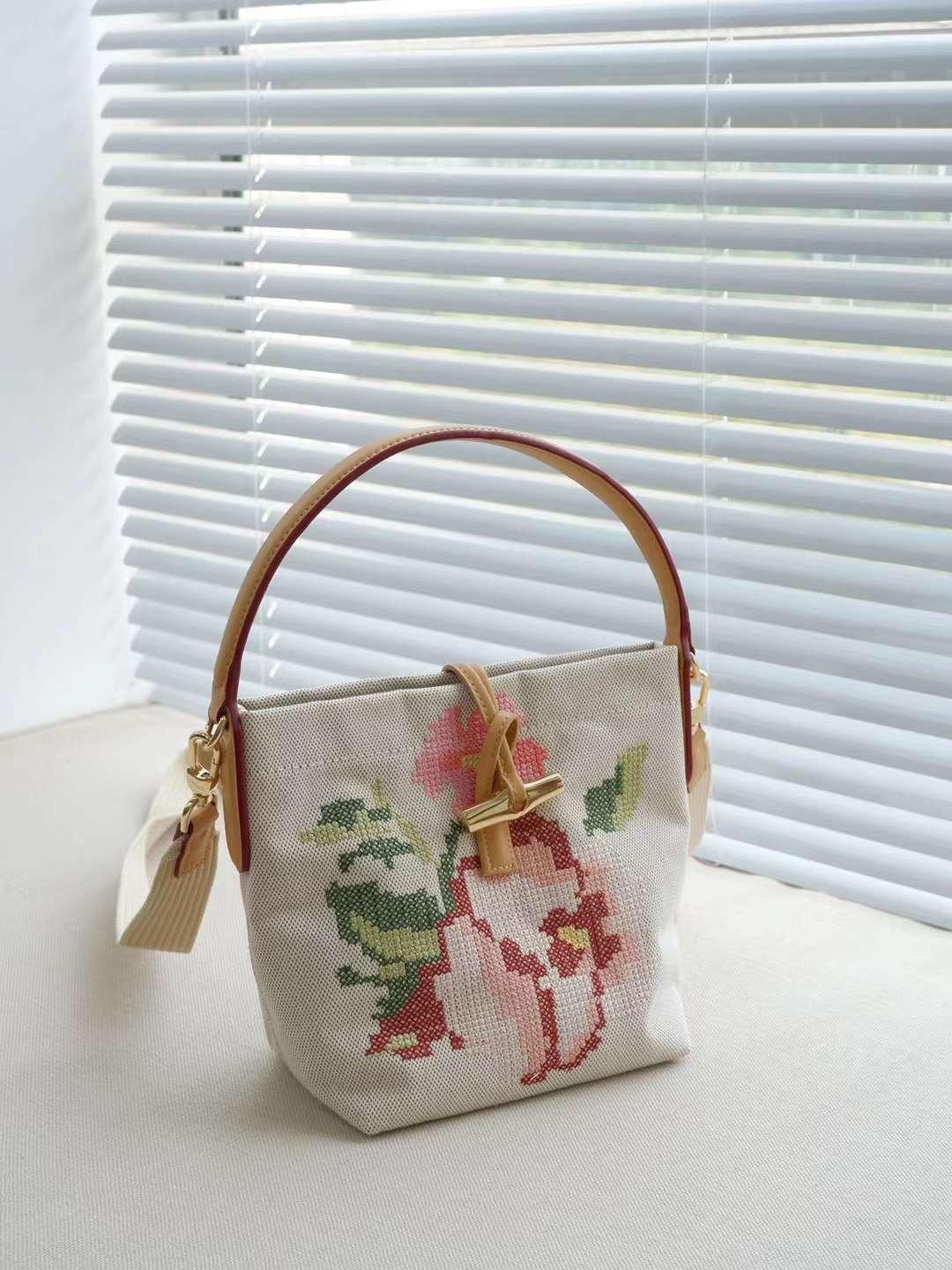 LONGCHAMP ROSEAU ESSENTIAL FLEURS Bucket bag S - กระเป๋าทรงถังขนาดเล็ก วัสดุผ้าฝ้าย ลายปักษ์ดอกกุหลาบ Roseau เป็นคอลเล็คชั่นที่สดใสและเรียบง่าย ซับในสีพื้น อะไหล่สีทอง น้ำหนักเบา จุของได้เยอะ มีสายสะพายไล่ ถอดสายได้ Crossbody ได้