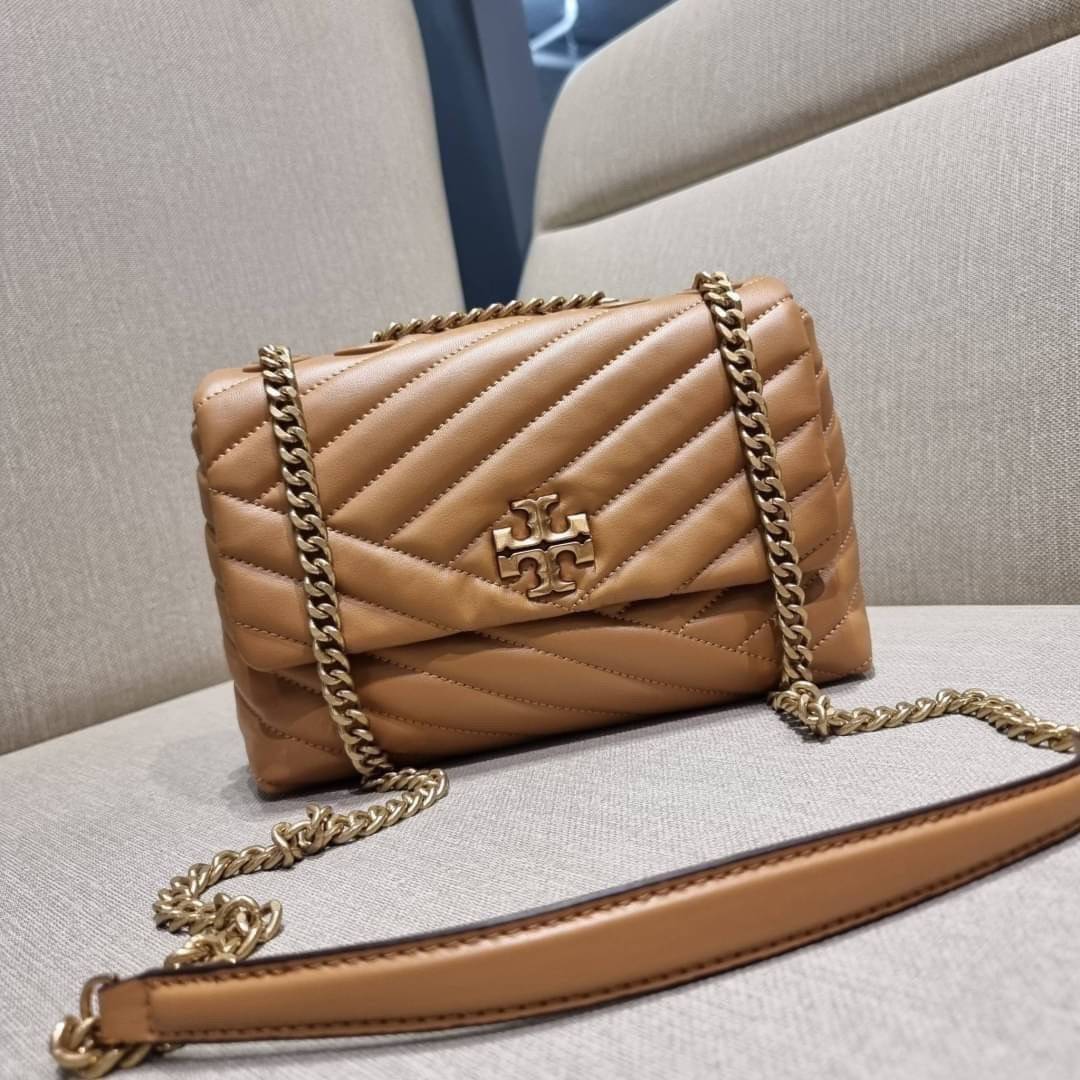 TORY BURCH KIRA CHEVRON CONVERTIBLE SHOULDER BAG (SMALL / MEDIUM) กระเป๋าสะพายรุ่นยอดฮิต ไซส์คลาสสิค ที่ใช้ยังไงก็ดูหรู ดีไซน์เฉพาะตัว วัสดุหนังแกะ สัมผัสนิ่ม เปิด-ปิดด้วยกระดุมแม่เหล็ก ภายในเป็นช่องโล่ง ใส่กระเป๋าสตางค์ มือถือ เครื่องสำอางค์ พาวเวอร์แบงค