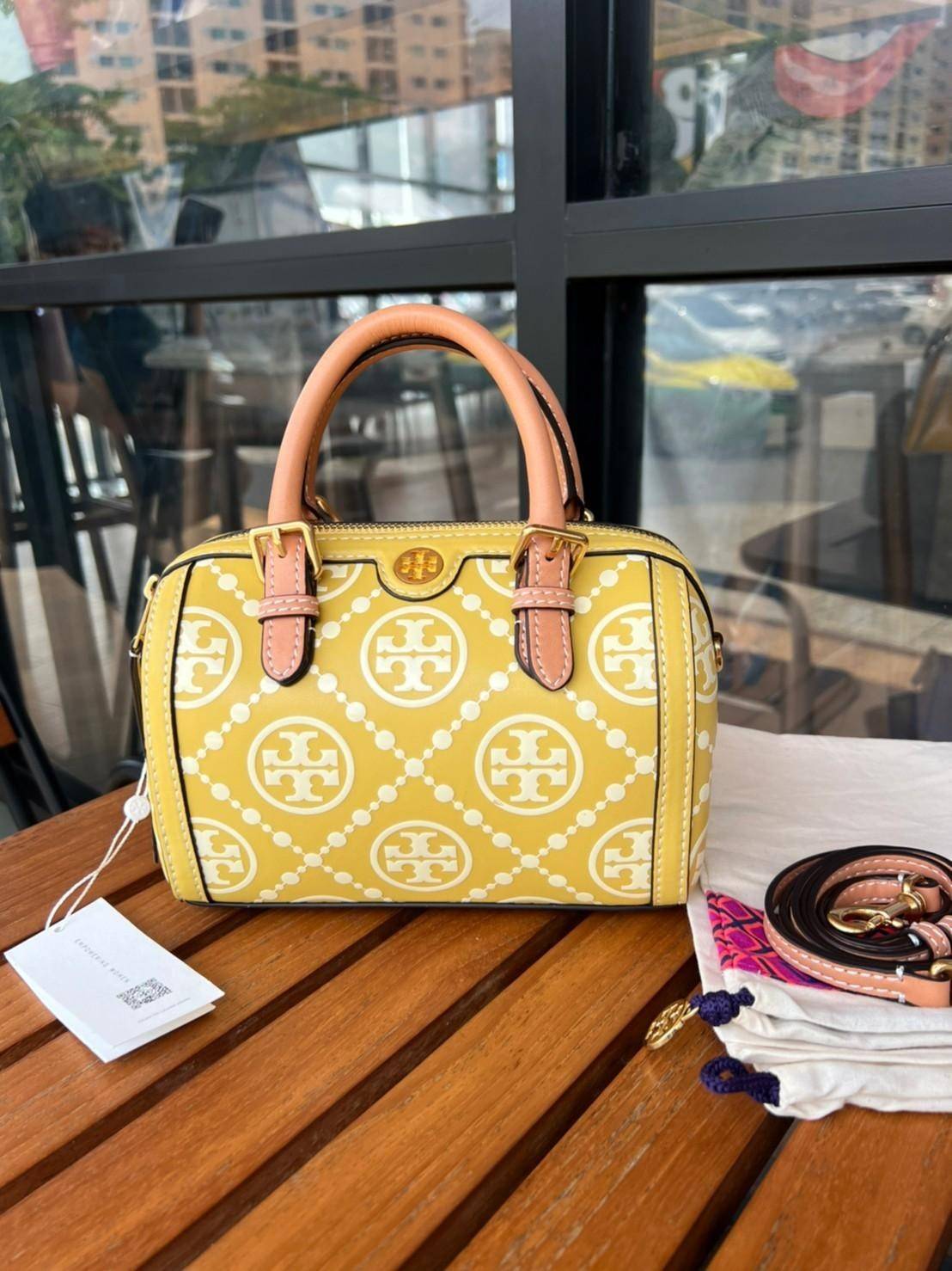 Tory Burch T-Monogram Mini Embossed Wine Bucket Bag / Tory Burch Mini Bucket กระเป๋าถือหรือสะพายไหล่ ทรงหมอนขนาดเล็ก ประดับด้วยลวดลายอันเป็นสัญลักษณ์ของแบรนด์ ถูกประดิษขึ้นด้วยความพิถีพิถันวัสดุหนังอย่างดี ด้านในบุด้วยหนังไมโครซูแอคเนื้อนุ่มทำความสะอาดง่า