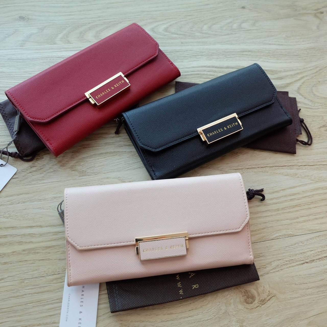 Charles & Keith Push-Lock Long Wallet กระเป๋าเงินใบยาววัสดุหนังลายคาร์เวียร์ ด้านหน้าปั๊มโลโก้แบรนด์ เปิดปิดแบบตัวล็อก ด้านในมีช่องซิปใส่เหรียญและธนบัตร ด้านหลัง มีตัวล็อคแบบกระดุม จุบัตรได้ถึง 12 ใบ รุ่นนี้สวยหรูเกินราคา ด้านหน้าเปิด - ปิดด้วยตัวกดล็อคทั