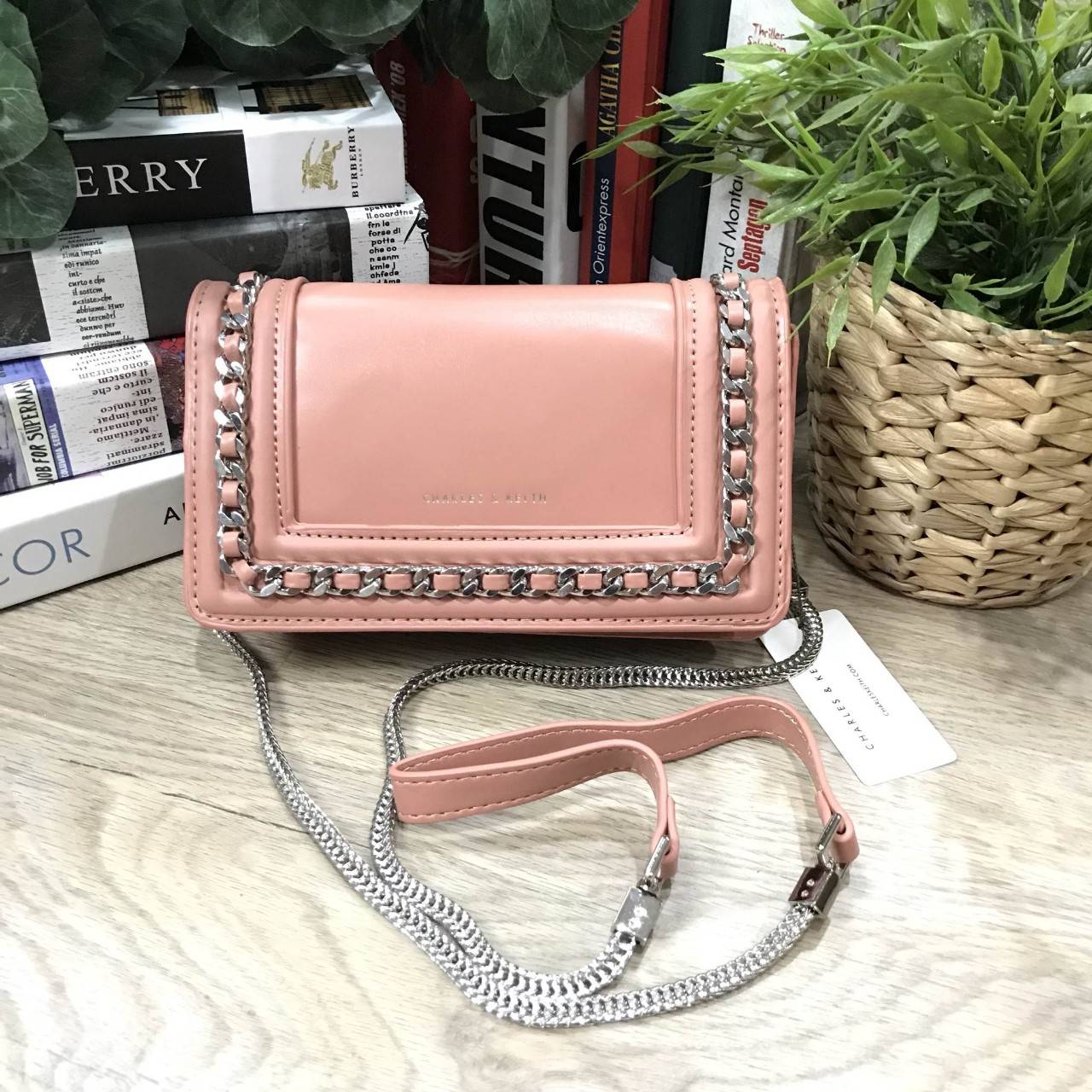 NEW ARRIVAL! CHARLES & KEITH CHAIN DETAIL CROSSBODY BAG กระเป๋าสะพายทรงสี่เหลี่ยมรุ่นชนช็อปขนาดกำลังดีวัสดุหนังนิ่มเรียบประดับด้วยโซ่ด้านหน้าดูมีดีเทล เปิดปิดด้วยกระดุมแม่เหล็ก ภายในมีช่องใส่บัตรและช่องซิป มาพร้อมสายโซ่ต่อหนังถอดถือเป็นคลัชได้ ภาพถ่ายสินค