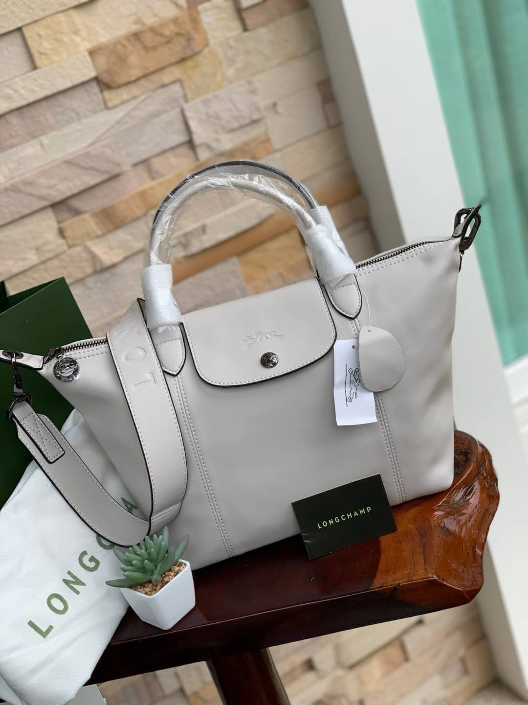 Longchamp LE PLIAGE CUIR TOP HANDLE BAG S เรียกว่าเป็นกระเป๋าอีกหนึ่งรุ่นที่ไม่ว่ายังไงก็ฮอตฮิตและติดเทรนด์ตลอดไม่เคยเปลี่ยนกับ ทรง Le Pliage Cuir หนึ่งในตระกูลกระเป๋าสุดไอคอนิกจากแบรนด์ เมื่อรุ่น Le Pliage Cuir ในรูปแบบของหนังแกะ Metis ได้ถือกำเนิดขึ้นใน