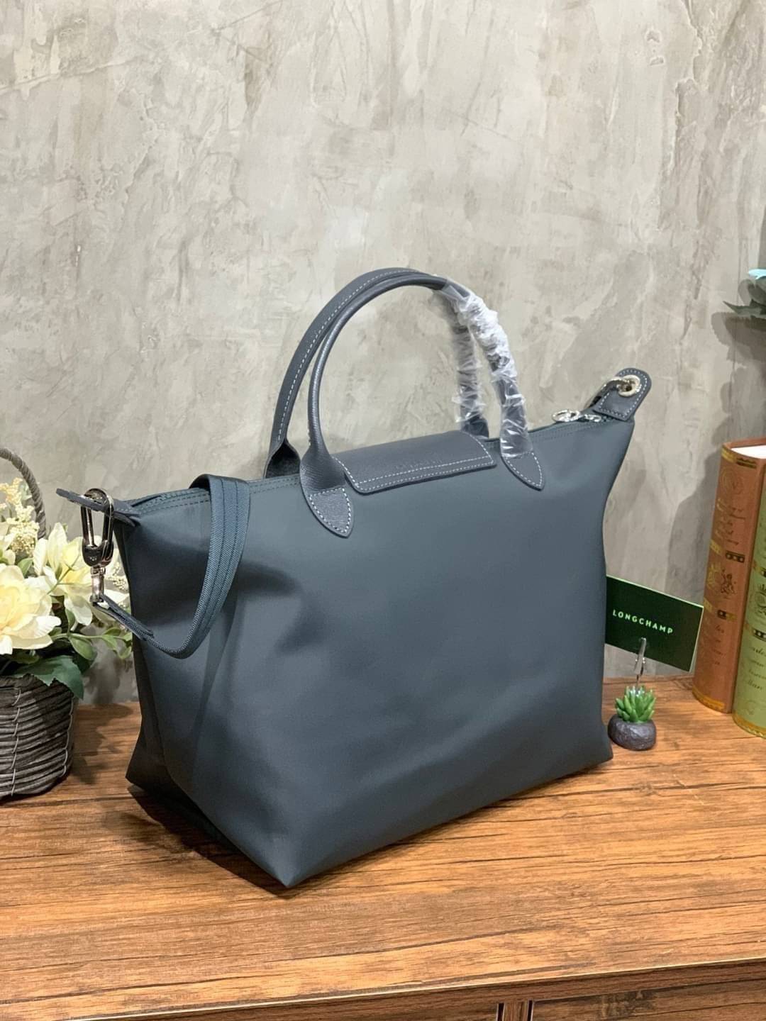 Longchamp Le Pliage Neo Size M มาพบกับกระเป๋ารุ่นยอดนิยม ที่สาวๆ ต้องมีไว้เก็บไว้สักใบ กระเป๋าโท้ทใบนี้ มาพร้อมกับสีที่มีสไตล์เรียบง่าย มีสายสะพายยาวช่วยให้คุณสามารถสะพายไหล่ได้อย่างสบาย ในขณะที่ที่ปิดแบบซิปช่วยให้คุณมั่นใจได้ว่าของด้านในมีความปลอดภัย Le 