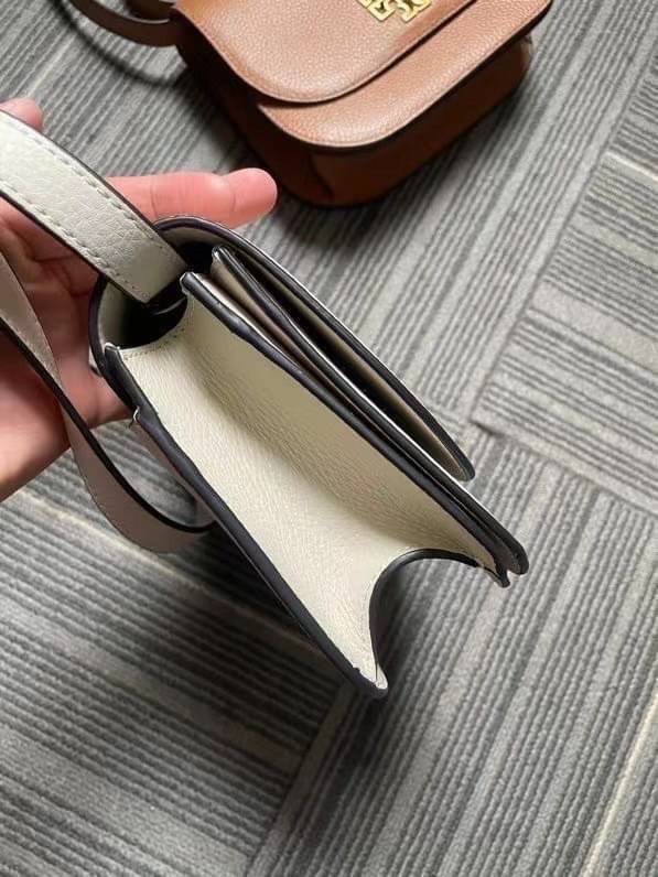TORY BURCH BRLTTEN SMALL SADDLE BAG / Tory Burch Britten Flap Shoulder Bag กระเป๋าสะพายข้าง วัสดุหนังแกะแท้ ด้านหน้าประดับโลโก้แบรนด์ เปิด-ปิดกระเป๋าแบบกระดุมแป็กแม่เหล็กแน่นหนา ภายในมีช่องหลัก ใส่กระเป๋าเงินใบกลาง มือถือได้ทุกรุ่น มีช่องแยกใส่ของจุกจิกอี
