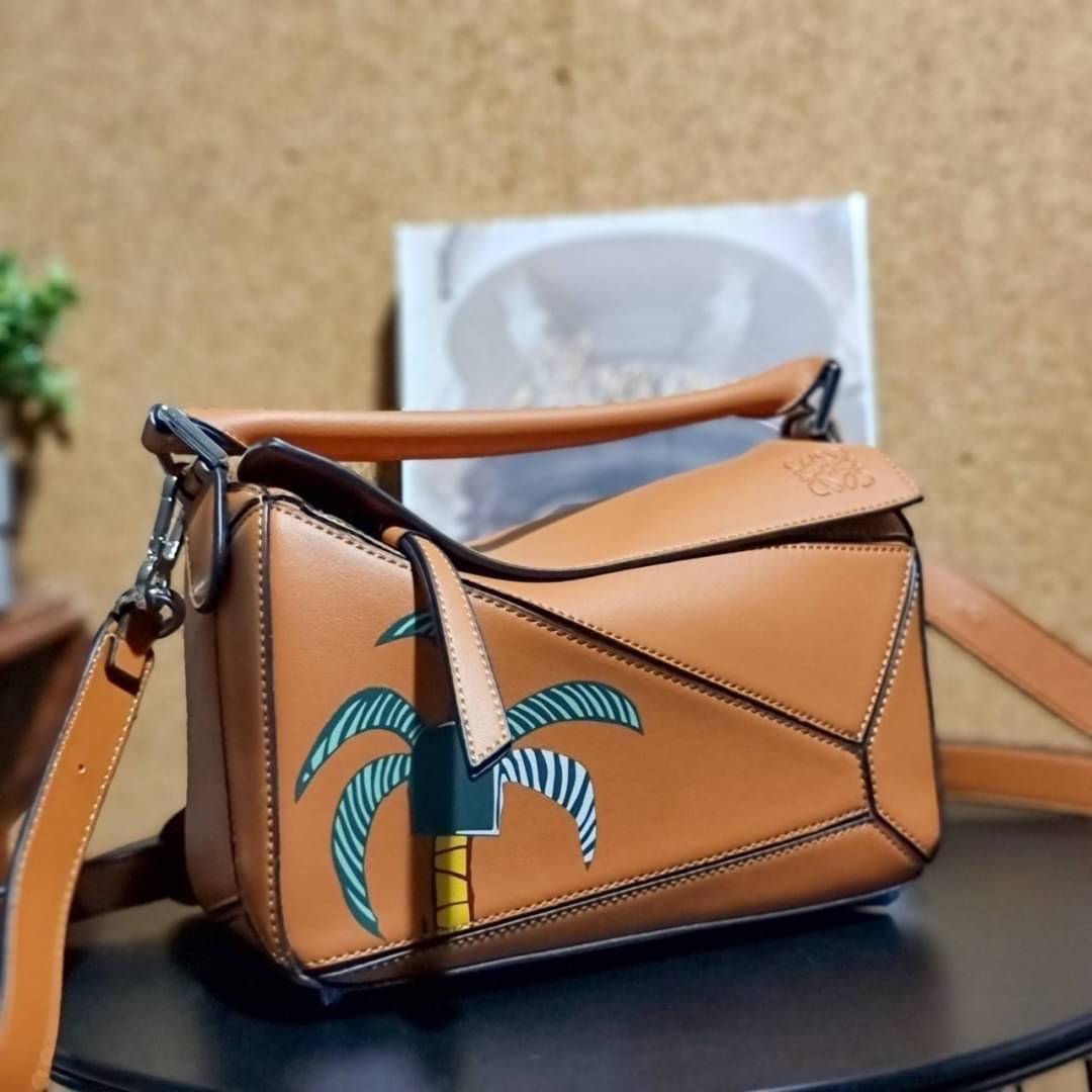 VIP 】LOEWE LA PALME PUZZLE BAG IN CLASSIC CALFSKIN คอลเลคชั่นใหม่!! กระเป๋าสะพายข้างทรงกล่อง สไตล์พัซเซิล ให้ฟีลลิ่งเหมือนตัวต่อ ดูดีได้ทุกที่แค่มีใบนี้ รอบนี้ดีไซน์พริ้นท์ลายต้นปาล์มเก๋ๆ ซัมเมอร์ยังต้องมา วัสดุหนังวัวฟอกสี เปิดใช้งานด้วยซิป ที่ภายในโล่งพ