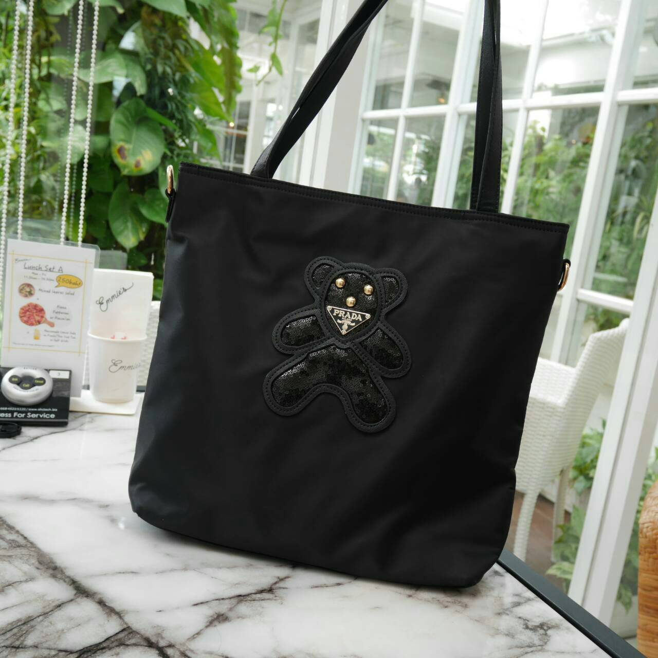 ReStock! งานขายดี ได้ กระเป๋าสะพายไหล่ ทรง TOTE จากแบรนด์ PRADA มาค่า เป็น กระเป๋าผ้าไนล่อน ตามแบบฉบับของแบรนด์เลย ใบนี้มีสายยาวให้ค่ะ สะพายเป็น shoulder bag หรือ ถือได้ค่ะ ด้านหน้าเป็นลายหมี ปักกลิ้ตเตอร์ +logo brand ใช้แล้วสวยมากๆ อะไหล่ทองหรูมาก จุของค