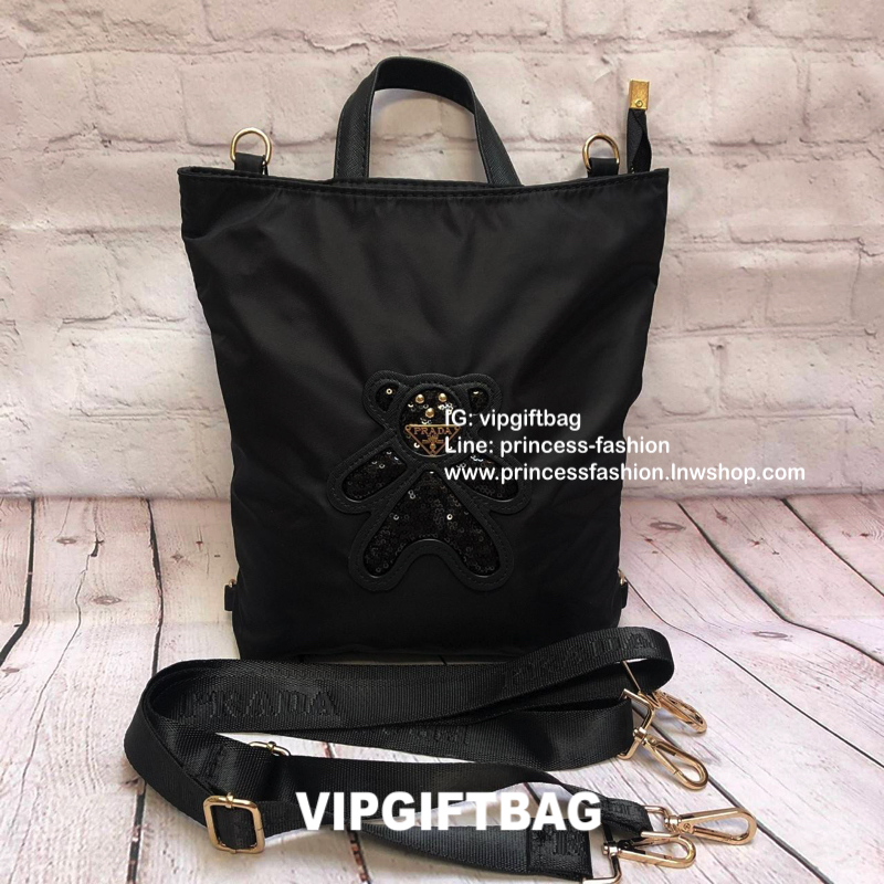 กระเป๋าสะพาย ทรง TOTE จากแบรนด์ PRADA มาค่า ตัวกระเป๋าเป็น nylon ทั้งใบ สะพายเป็น shoulder bag หรือถือได้ค่ะหรือสะพายเป็นเป้ก้ยังได้ ด้านหน้าเป็นลายหมี ปักกลิ้ตเตอร์ + logo brand ใช้แล้วสวยมากๆ อะไหล่ทองหรูมาก จุของคุ้ม ใส่หนังสือหรือของจุกจิกก็ไ้ด้หมด สว