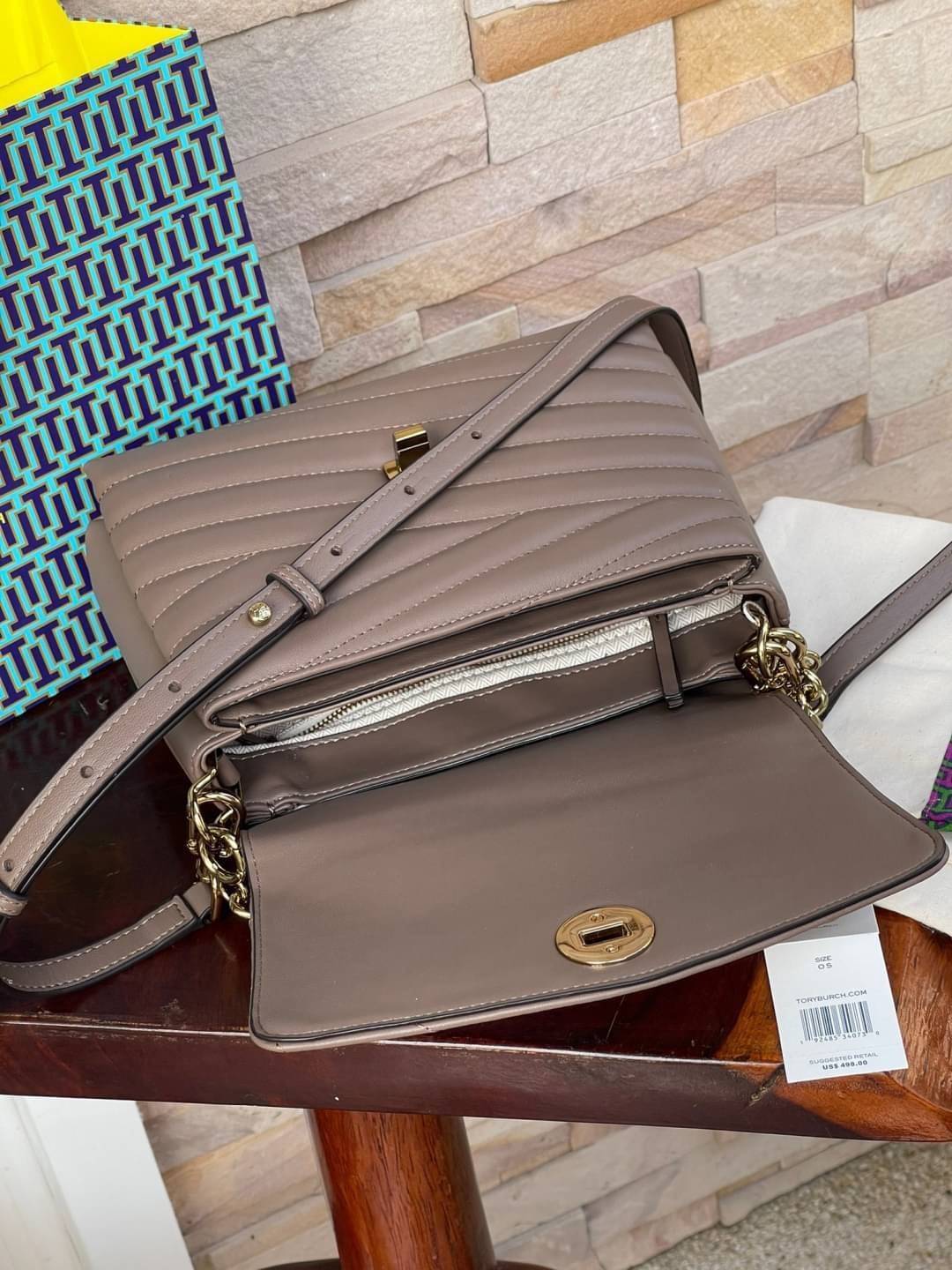 TORY BURCH Kira Chevron Top-handle Satchel กระเป๋าหนังแกะ สัมผัสนุ่มควบคู่กับดีไซน์อันเป็นเอกลักษณ์ กระเป๋าถือทรงสวยที่มีดีไซน์อันเป็นเอกลักษณ์ไม่เหมือนกับที่ไหน ด้วยการตัดเย็บหนังแกะแสนนุ่มแบบลายบุสองชั้น เพิ่มมูลค่าด้วยสายสะพายที่ทำจากโลหะสีทอง อีกทั้งย