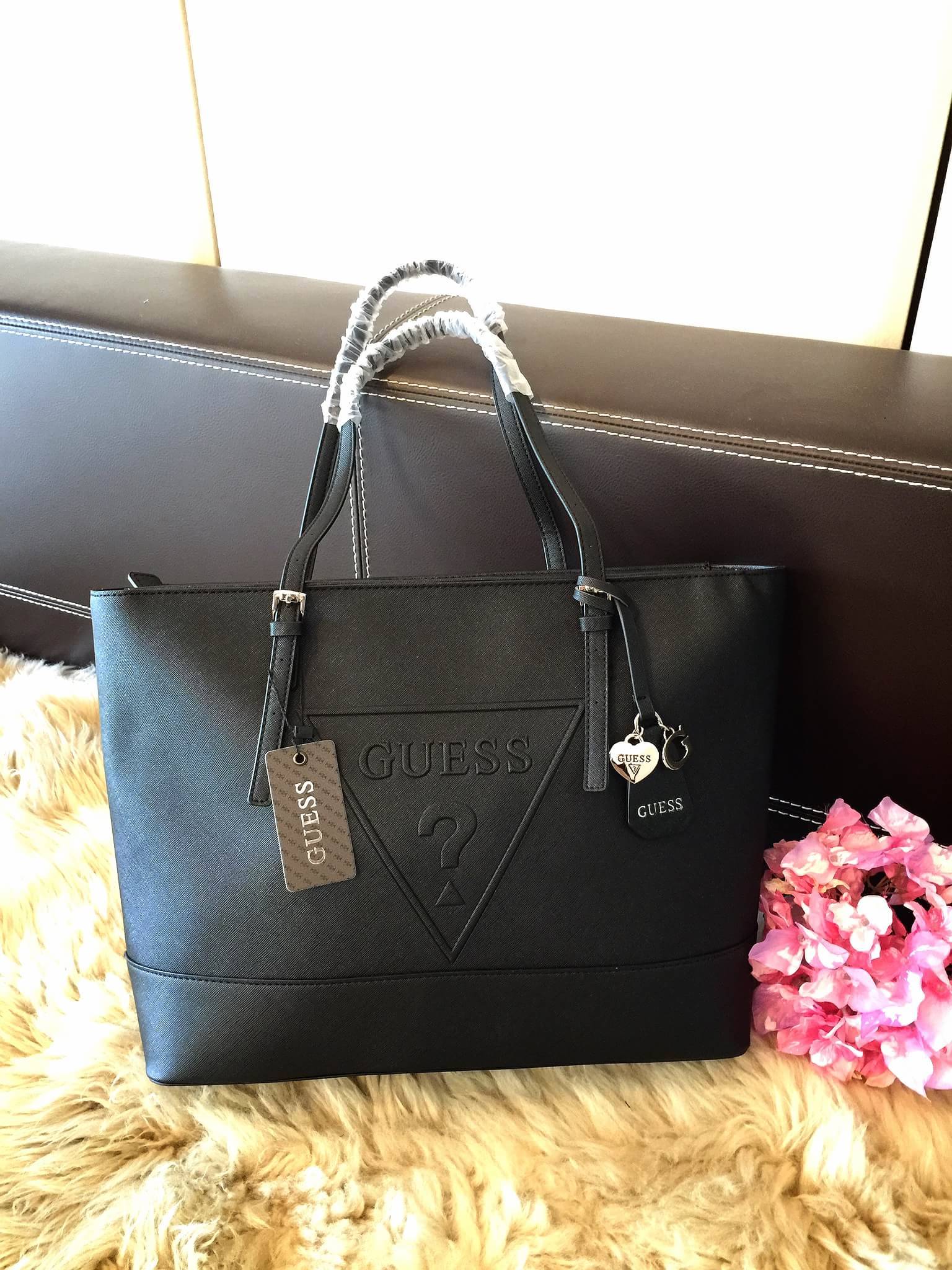 Guess Saffiano Shopping Bag กระเป๋าถือและคล้องบ่าทรงช้อปปิ้งใบใหญ่ หนังSaffiano ใส่เอกสารขนาด A4 ได้ จุของได้เยอะ ด้านหน้าสลักแบรนด์หนังลายนูนพร้อมประดับtagสายหนังถอดออกได้ เปิดปิดด้วยซิปเดียวด้านบน ภายในบุผ้าติดโลโก้ มีช่องเล็กและข่องใส่โทรศัพท์ เรียบง่า