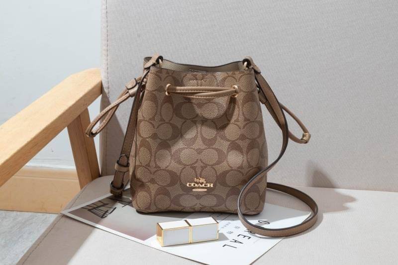 Coach Lena Crossbody Signature Bucket Bag กระเป๋าสะพายไหล่สุดคลาสสิกรุ่นนี้ เป็นรูปทรงถัง ที่สามารถจุของได้กำลังดี สำหรับสาวๆสายแฟชั่นที่ชอบรายละเอียดชิคๆ ดีไซน์เก๋ ด้วยรูปทรงของกระเป๋าที่ออกแบบมาให้ฐานเป็นรูปสี่เหลี่ยมทำให้กระเป๋ายังคงรูปทรงได้ง่าย มีสาย