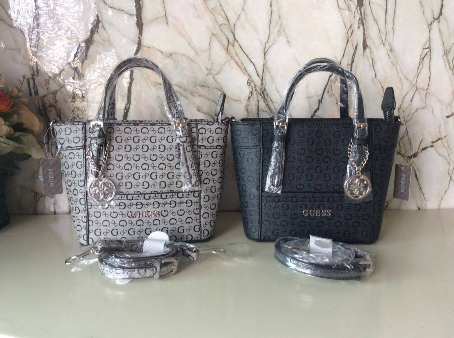 Don’t Miss! GUESS CATE MINI CROSS BODY BAG กระเป๋าถือหรือสะพายรุ่นที่ฮิตและขายดีที่สุดจาก GUESS FACTORY หนัง Saffiano ลาย GUESS Signature สวยอยู่ทรง ขนาดกำลังดี น้ำหนักเบา ด้านหน้าประดับโลโก้พร้อมพวงกุญแจโลโก้แบรนด์ห้อยที่หูกระเป๋าถอดเเยกใช้ได้ เปิดปิดด้ว
