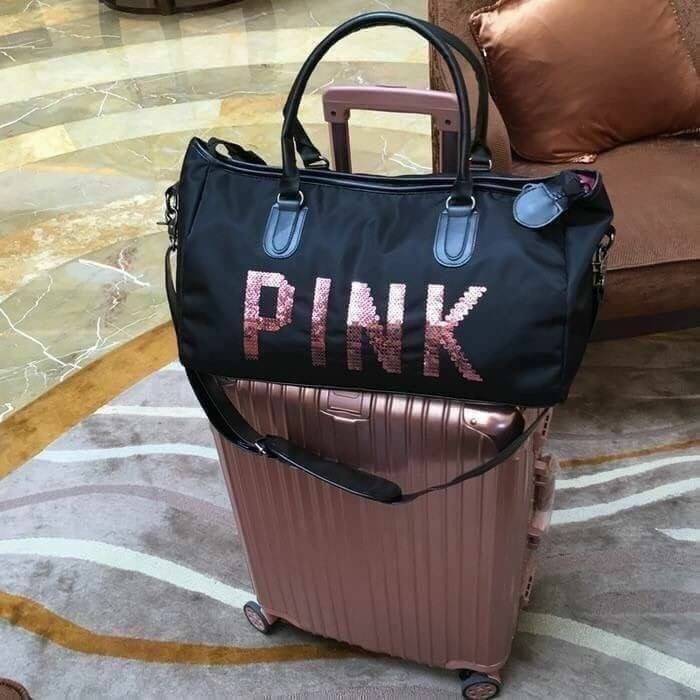 Victorias Secret PINK กระเป๋าสไตล์กระเป๋าเดินทาง หรือสะพายไปเล่นฟิตเนส ด้านหน้าจะมีตัวอักษร PINK เลื่อมสีชมพู เปิดปิดด้วยซิป ภายในมีช่องใหญ่ จุของได้เยอะ มีช่องใส่โทรศัพท์หรือของจุกจิก สามารถใส่เสื้อผ้าได้หลายชุด สายสะพายปรับระดับได้ และมีที่วางบ่าให้ด้วย