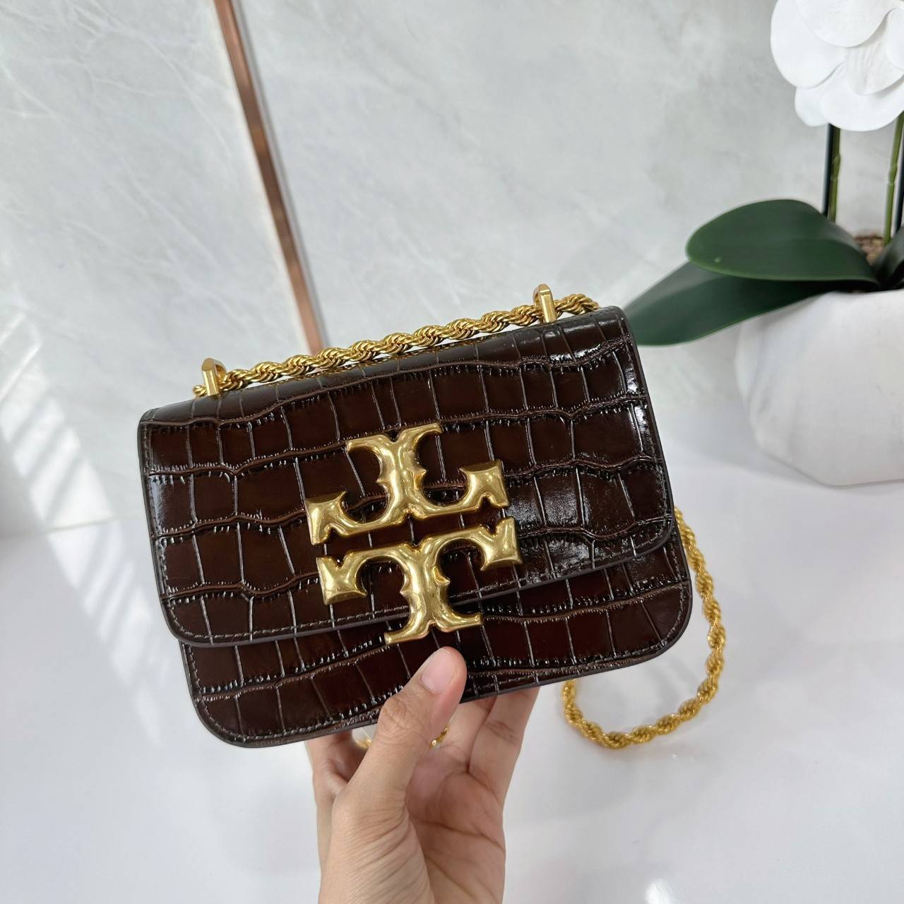 6 สี Tory Burch Croc Eleanor Small Bag / TORY BURCH ELEANOR CROC EMBOSSED LEATHER กระเป๋าสะพายหนังพิมพ์ลายจระเข้ ดีไซน์หรูหรา โด่นเด่นด้วยโลโก้แบรนด์อะไหล่ด้านหน้า และสายสะพายโลหะสีทอง