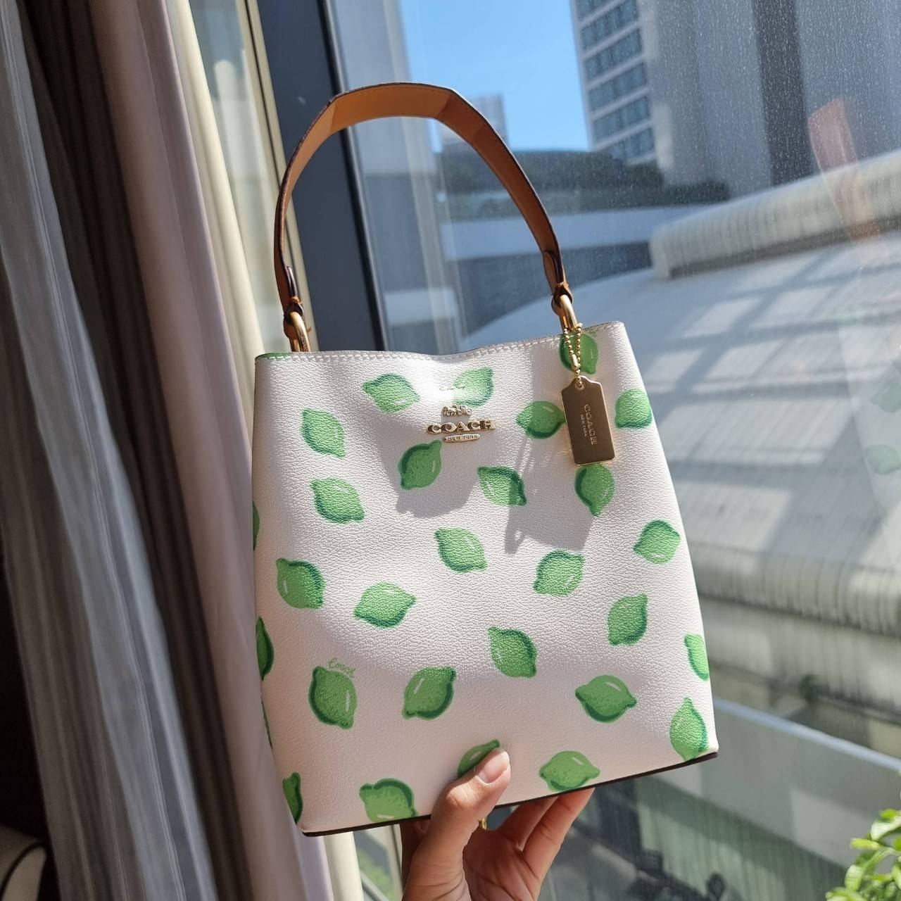 OUTTLET 】COACH 1625 SMALL TOWN BUCKET BAG WITH LIME PRINT ต้อนรับปีใหม่ด้วยความสดใส กับรุ่นยอดนิยม กระเป๋าทรงบัคเก็ตไซส์เล็ก ดีไซน์ลวดลายจี๊ดจ๊าด น่าใช้จริงจัง วัสดุหนังแคนวาสเคลือบลาย สวยคมแซ่บมากๆ เปิด-ปิดด้วยกระดุมแม่เหล็กทั้ง 2 ฝั่ง ภายในเป็นช่องโล่ง 