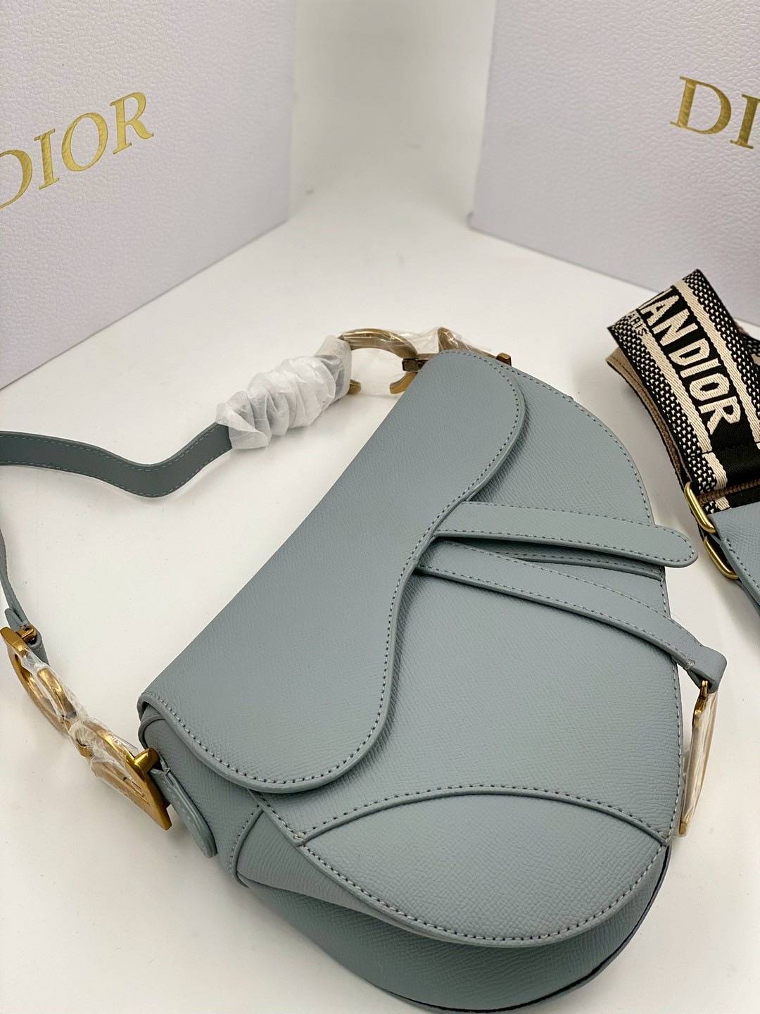 ORI หนังแท้ | DIOR Saddle Bag with Strap Grained Leather กระเป๋าถือ/สะพายทรงอานม้า รุ่นยอดนิยมที่มีเอกลักษณ์สวยงามเหนือกาลเวลา ลูกเล่นห้อยด้วยตัวอักษร D ตรงหูหิ้วมีกิมมิค CD สวยหรูดูแพง