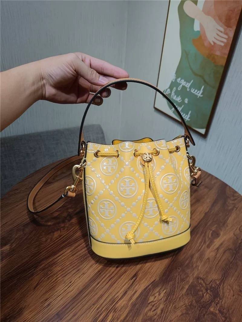 Medium : Tory Burch T Monogram Embossed Bucket Bag กระเป๋าถือหรือสะพายไหล่ ประดับด้วยลวดลายอันเป็นสัญลักษณ์ของแบรนด์ ถูกประดิษขึ้นด้วยความพิถีพิถันวัสดุหนังอย่างดี ด้านในบุด้วยหนังไมโครซูแอคเนื้อนุ่มทำความสะอาดง่าย กระเป๋าผ่าหลังด้านนอก1ช่อง ด้านใน 1ช่อง 
