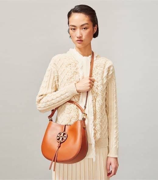 Tory burch miller metal-logo mini hobo bag มีกลิ่นอายสุดคลาสสิก ได้รับแรงบันดาลใจมาจากการขี่ม้า จึงได้ดีไซน์กระเป๋าออกมาในรูปแบบอานหลังม้าสุดเก๋ที่สามารถนำไปมิกซ์แอนด์แมทช์กับสไตล์การแต่งตัวได้หลายชนิด ไม่ว่าจะเป็นกับเดรสทรงยาวหรือกางเกงยีนแสนเท่ตัวโปรดขอ
