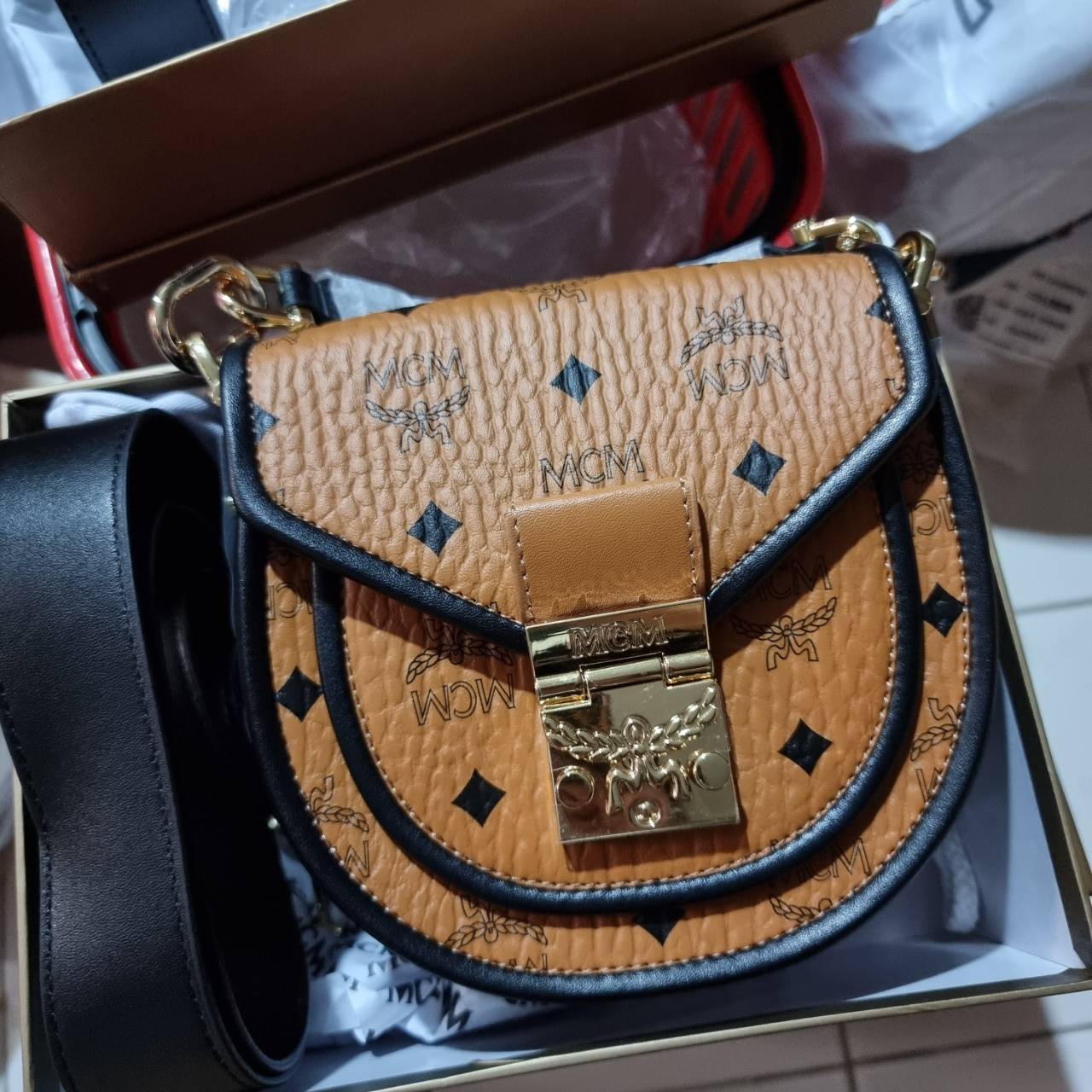 M.C.M MINI PATRICIA SHOULDER BAG IN VISETOS LEATHER BLOCK อัพเลเวลกระเป๋าของคุณด้วยไอเท็มนี้ไปเลยจ้า กระเป๋าสะพายทรง saddle ที่เก๋ไม่ซ้ำใคร ดีไซน์ขอบสีดำเพิ่มความยูนิค สวยสะดุดตา วัสดุหนังแคนวาสคุณภาพดี มาพร้อมสายสะพายหนังสีดำเรียบ และหูจับในตัว ทำให้ใช้ง