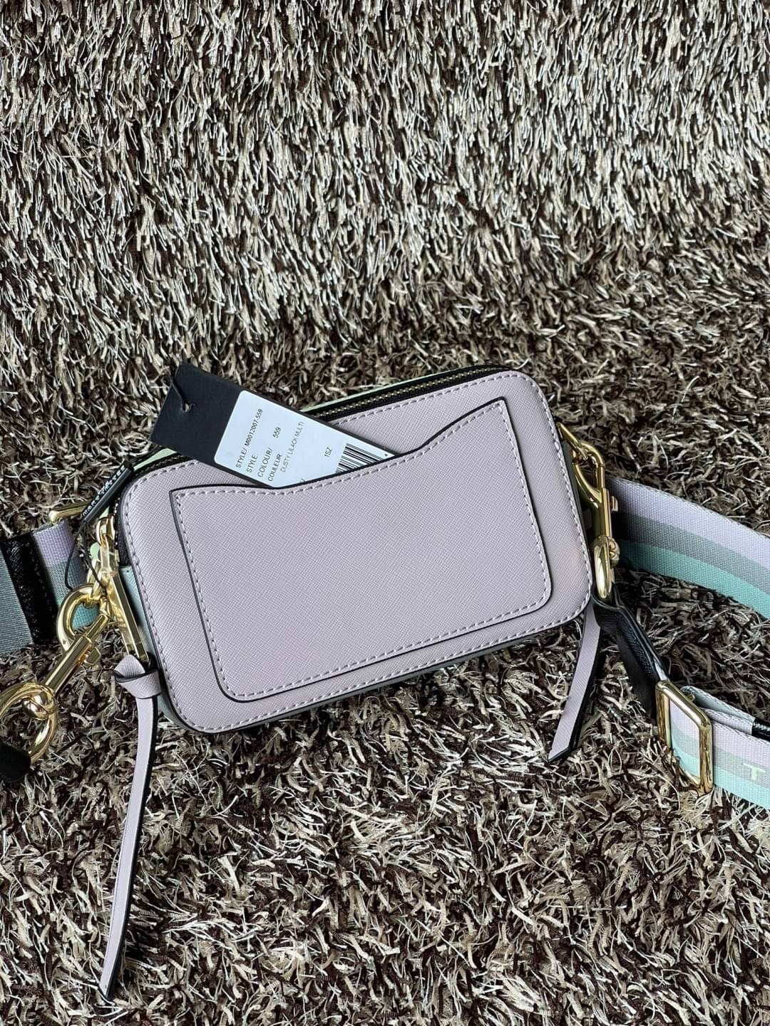 Marc Jacobs Snapshot Bag กระเป๋าแบรนด์ดังจากสัญชาติอเมริกัน นับได้ว่ารุ่นนี้เป็นรุ่นทรงฮิตเลยทีเดียว โดยด้านหน้ากระเป๋าจะเป็นโลโก้แบบโลหะที่เป็นสัญลักษณ์ของแบรนด์นี้ มาพร้อมสายสะพายที่จะสะพายยังไงก็ดูโดดเด่น เพราะขนาดใหญ่ที่สกรีนตัวอักษรโลโก้ ในรูปแบบต่าง