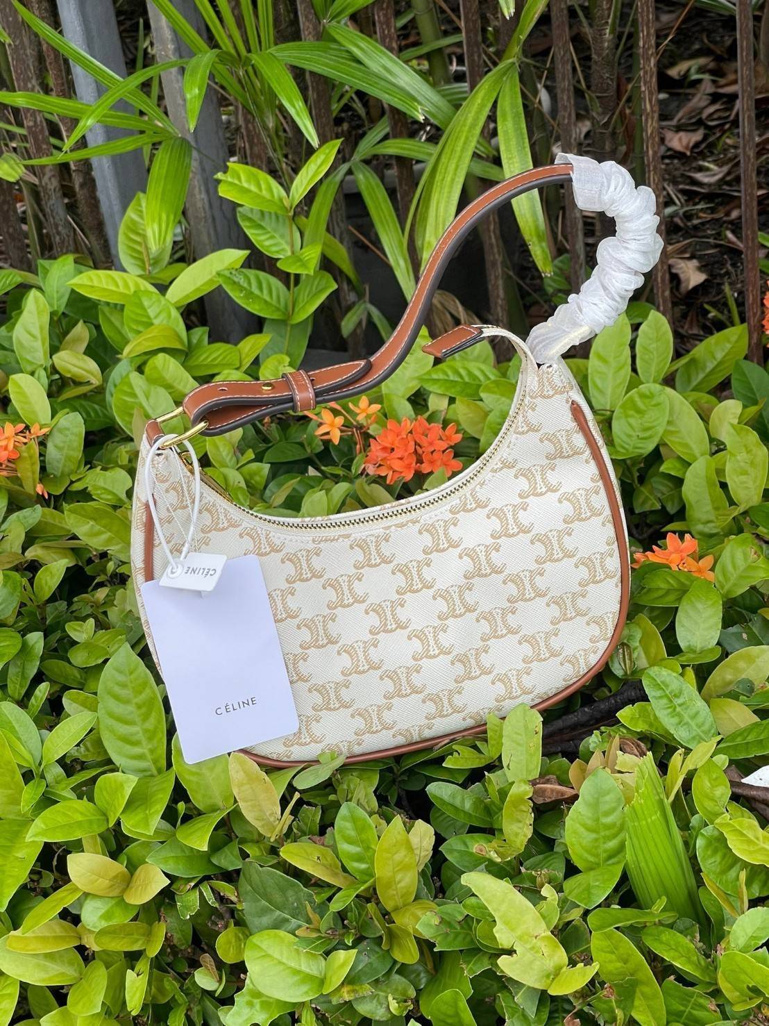 CELINE Vintage Classic Ava bag 1 ใน คอลเลคชั่น “Triomphe Canvas” มาพร้อมสายสะพายไหล่ที่ปรับความยาวได้ และเนื่องจากช่วงล่างของกระเป๋ามีขนาดใหญ่กว่าช่วงบน จึงทำให้ไม่เสียทรงเมื่อเราใส่สิ่งของอย่างกระเป๋าสตางค์หรือโทรศัพท์มือถือ หากดูภาพรวมแล้ว รุ่นนี้ออกแนว