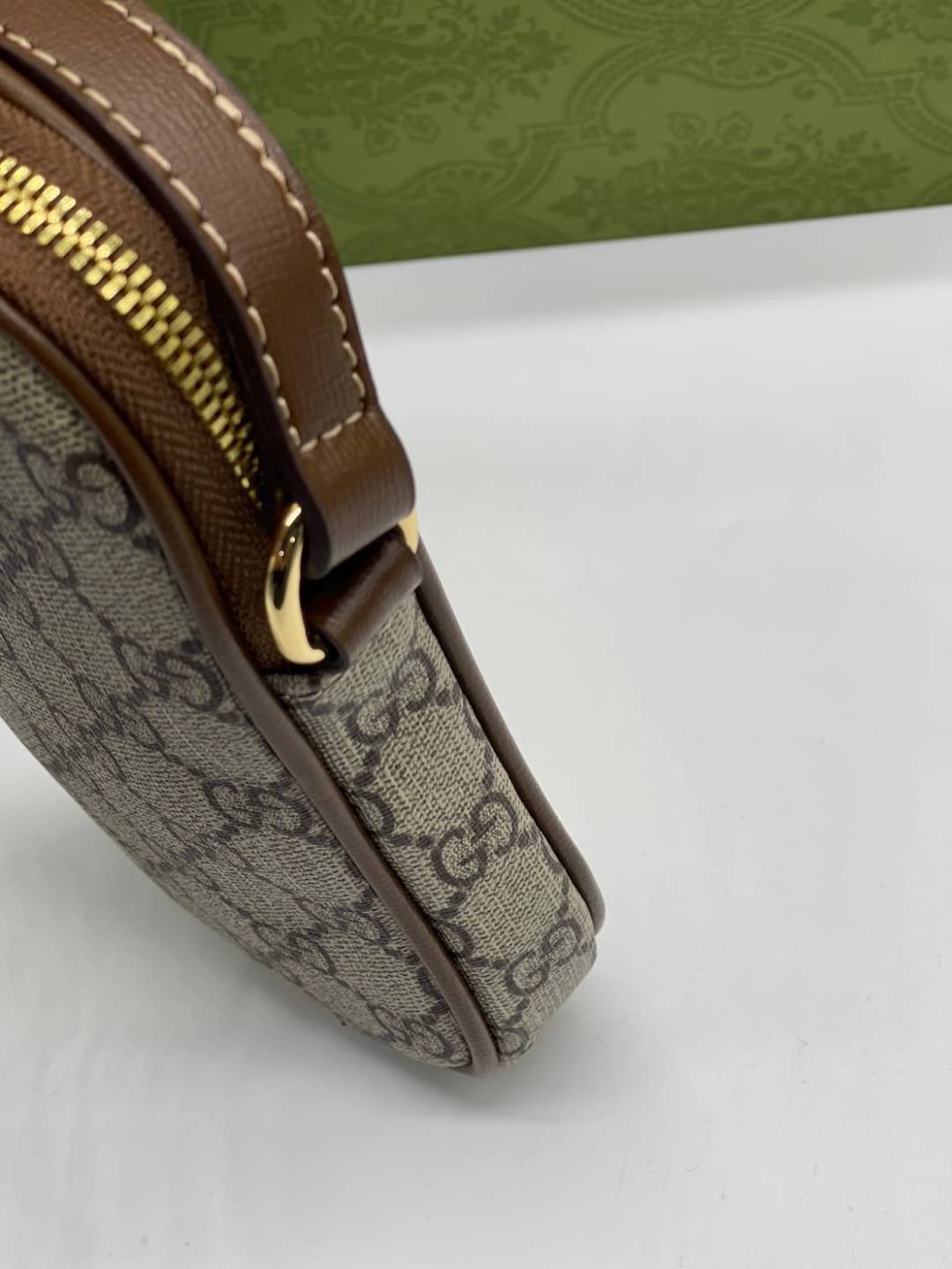 GUCCI Mini bag with Interlocking G / Gucci phone bag เกรดออริจินอล กระเป๋ามินิรังสรรค์จากผ้าแคนวาส Supreme ลายโมโนแกรมของแบรนด์สีเบจและสีน้ำตาลอีโบนี สัญลักษณ์ GG สไตล์นี้มอบความรู้สึกร่วมสมัยพร้อมกระเป๋าใส่ Apple AirPods ที่สามารถถอดออกได้