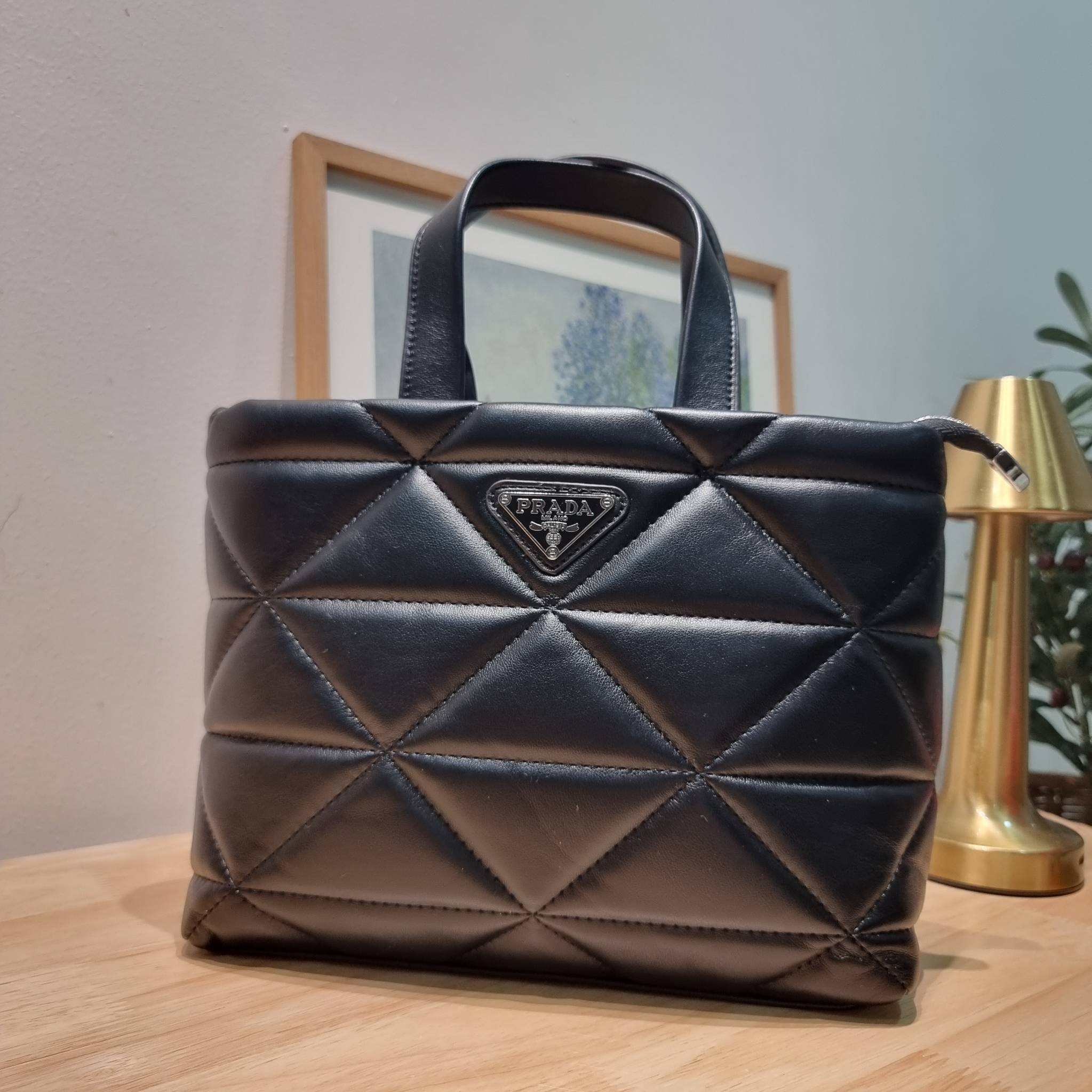 PRADA LEATHER PADDED BAG ใหม่ล่าสุด กับคอลเลคชั่นที่ทำออกมาตอบโจทย์ได้ทุกไลฟ์สไตล์ และเป็นยูนิเซ็กส์ กับกระเป๋าทรงโท้ท ขนาดกำลังดี