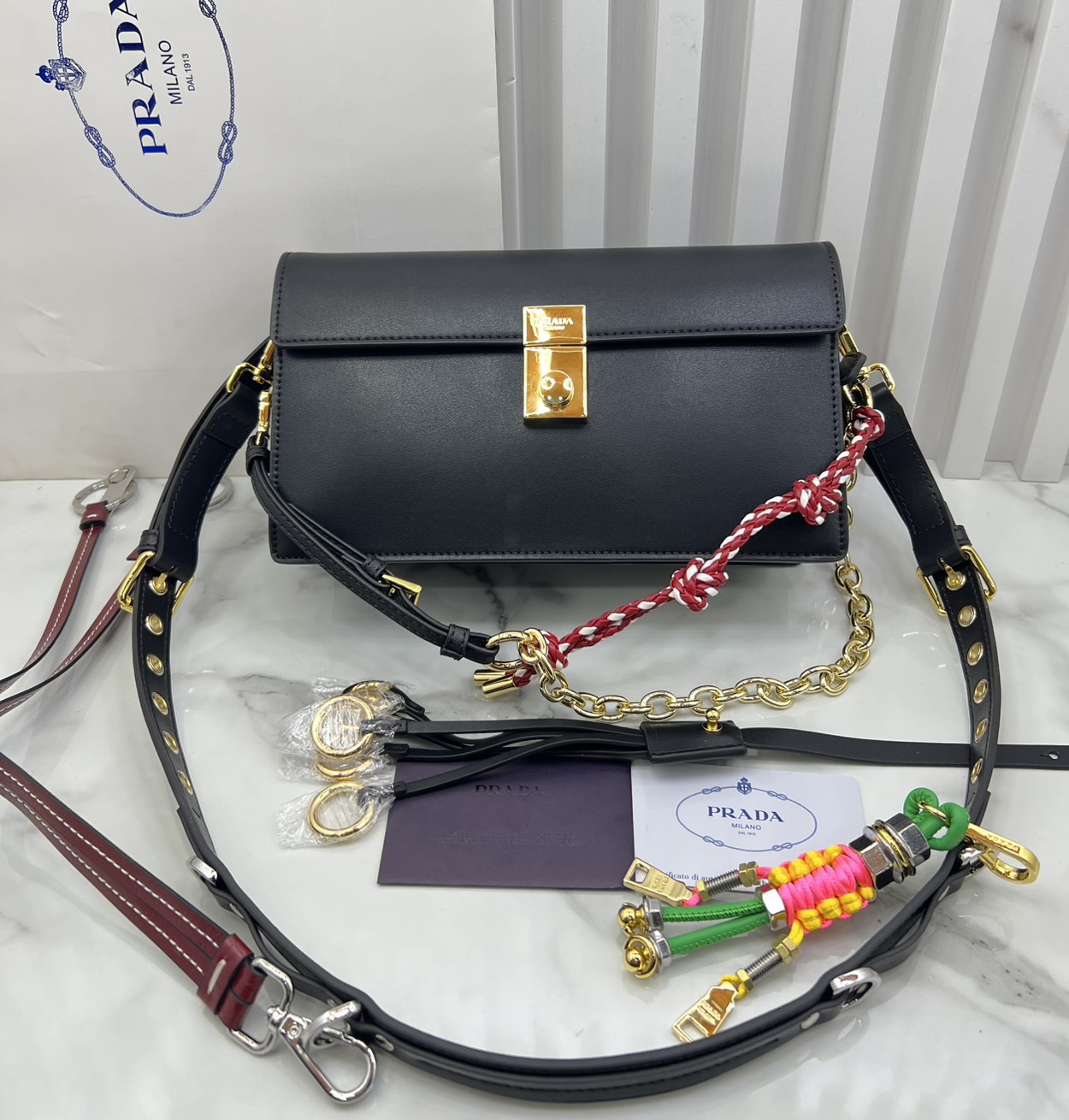 ORI หนังแท้ | 22cm Prada Soft Sound small leather shoulder bag with charms กระเป๋าสะพายทรงกล่อง รุ่นใหม่ล่าสุด มาแรงแบบเกินต้าน ด้วยดีไซน์เรียบ แต่มีกิมมิคเท่ห์ๆ ที่สายและพวงห้อยหลากสีสุดคิวท์