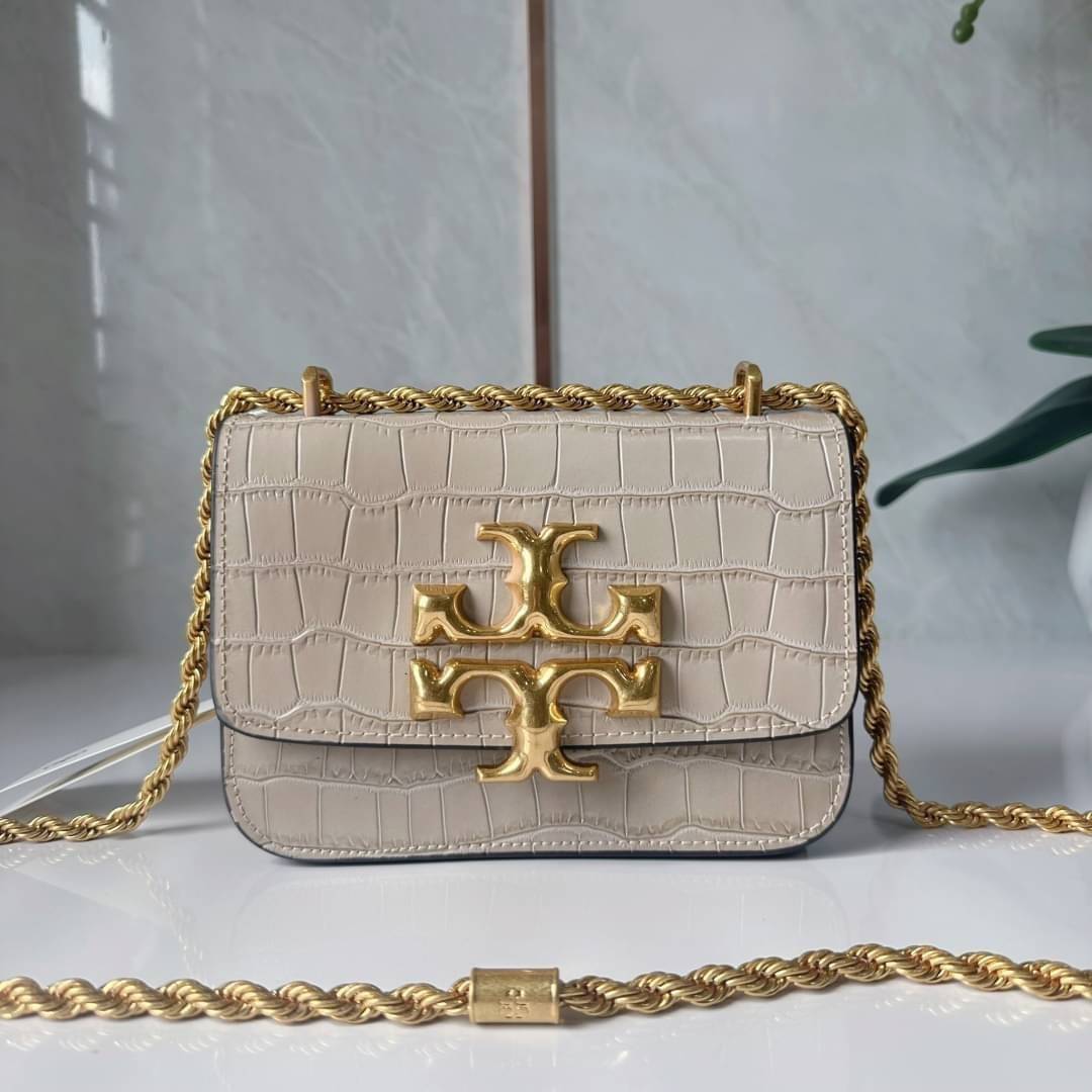 6 สี Tory Burch Croc Eleanor Small Bag / TORY BURCH ELEANOR CROC EMBOSSED LEATHER กระเป๋าสะพายหนังพิมพ์ลายจระเข้ ดีไซน์หรูหรา โด่นเด่นด้วยโลโก้แบรนด์อะไหล่ด้านหน้า และสายสะพายโลหะสีทอง