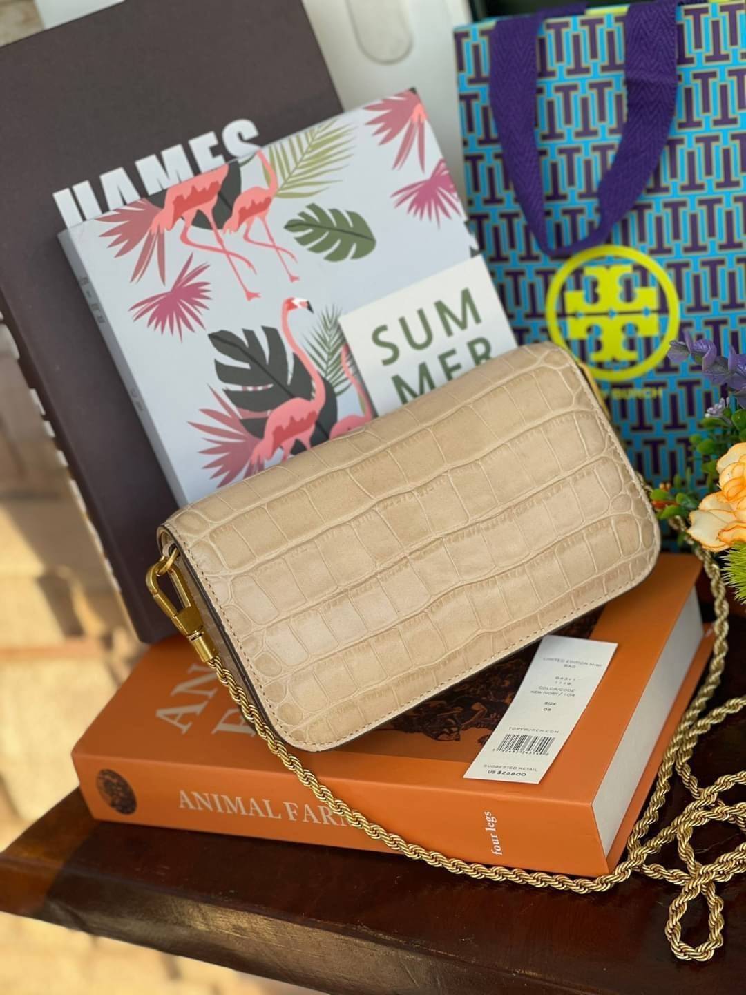 Tory Burch Eleanor Crocodile-Embossed Phone Crossbody Bag จุดเด่นของรุ่นนี้คือดีไซน์ออกมาในสไตล์คลาสสิกที่มาพร้อมกับฮาร์ดแวร์ที่ทำจากวัสดุทองเหลืองและสายสะพายโซ่เกลียวสีทอง ซึ่งการออกแบบได้รับแรงบันดาลใจมาจากเครื่องประดับ รูปทรงกะทัดรัดจึงสามารถสะพายใช้งา