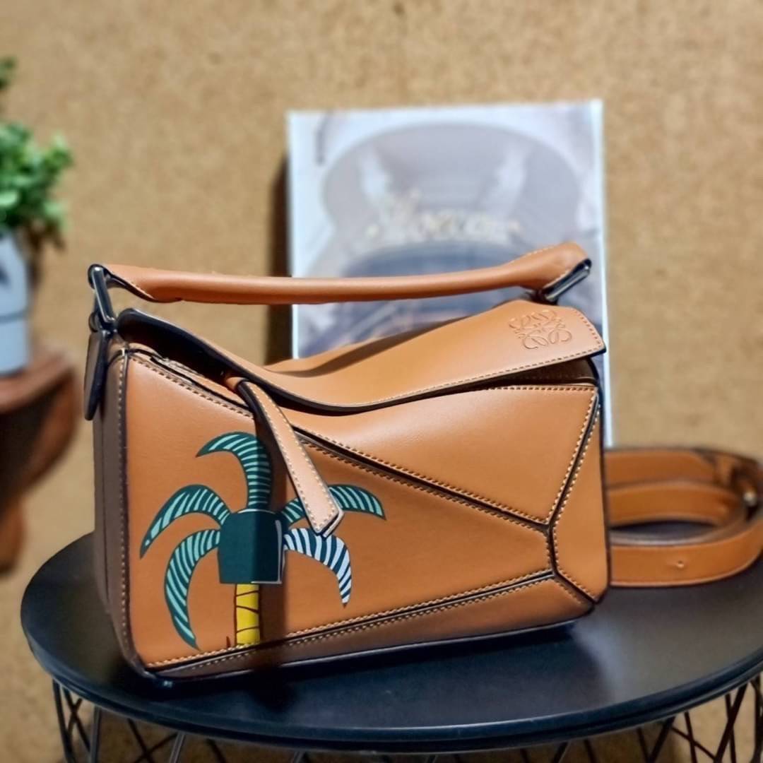 VIP 】LOEWE LA PALME PUZZLE BAG IN CLASSIC CALFSKIN คอลเลคชั่นใหม่!! กระเป๋าสะพายข้างทรงกล่อง สไตล์พัซเซิล ให้ฟีลลิ่งเหมือนตัวต่อ ดูดีได้ทุกที่แค่มีใบนี้ รอบนี้ดีไซน์พริ้นท์ลายต้นปาล์มเก๋ๆ ซัมเมอร์ยังต้องมา วัสดุหนังวัวฟอกสี เปิดใช้งานด้วยซิป ที่ภายในโล่งพ