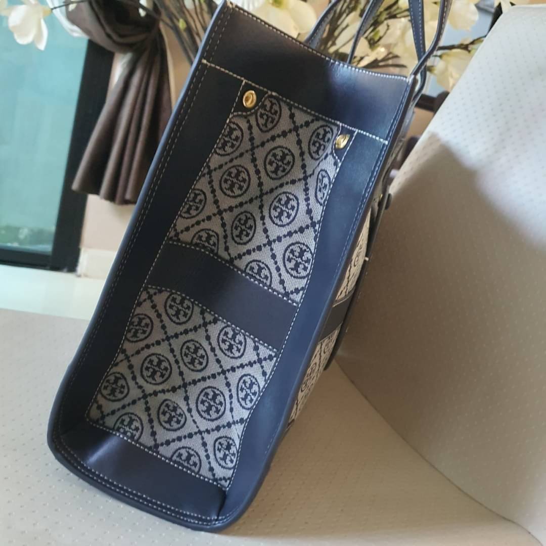 OUTTLET 】TORY BURCH TOTE BAG วัสดุ CANVAS ทั้งใบตัดด้วยหนังแท้สี NAVY ตัวกระเป๋าตั้งอยู่ทรงสวย แต่งโลโก้แบรนด์ด้านหน้า ด้านข้างมีกระดุม สามารถขยายทรงได้ ด้านในเปิดปิดด้วยกระดุมแม่เหล็ก ช่องกว้างหลักหนึ่งช่องและช่องซิปอีกช่อง สามารถใส่กระเป๋าสตางค์ยาว สมุด