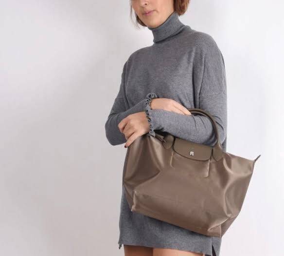 Longchamp LE PLIAGE NÉO TOP HANDLE BAG อีกหนึ่งรุ่นยอดนิยม ที่สาวๆ ต้องมีไว้เก็บไว้สักใบ กระเป๋าโท้ทใบนี้ มาพร้อมกับสีที่มีสไตล์เรียบง่าย มีสายสะพายยาวปรับสั้นยาวได้ช่วยให้คุณสามารถสะพายไหล่ได้อย่างสบาย ในตัวสายปักโลโก้อันเป็นสัญลักษณ์ ในขณะที่ที่ปิดแบบซิ