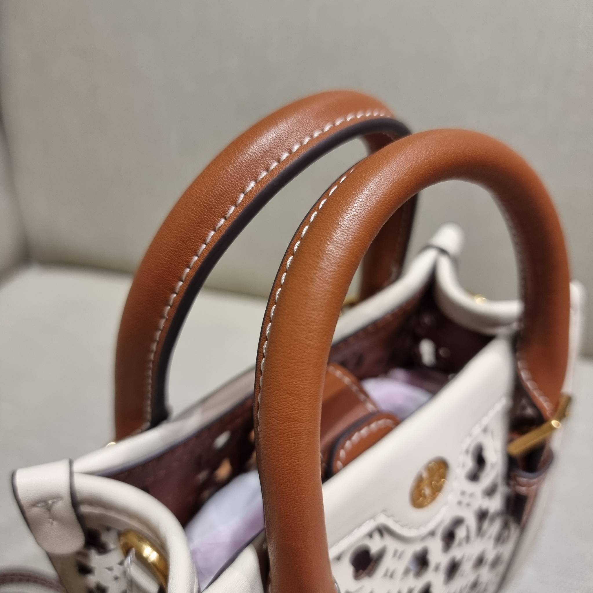 TORY BURCH T MONOGRAM LASER-CUT MINI TOTE ใจบางที่สุดกับคอลเลคชั่นนี้ กับกระเป๋าสะพายทรงโท้ท ไซส์มินิ ที่เพิ่มดีเทลความแพงด้วยการฉลุลวดลายโมโนแกรมรอบใบ ถักทอเป็นเส้นลายสานที่สวยงามมาก งานฝีมือจริงๆ วัสดุหนัง cowhide ปากกระเป๋ามีแถบแม่เหล็กกันหล่น และมีหูจ