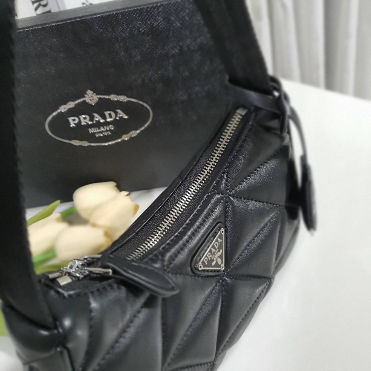 รุ่นใหม่แนะนำ!! กับงานพรีเมี่ยมกิ้ฟท์ PRADA HANDBAGS ขนาดกะทัดรัด **อะไหล่เงิน วัสดุทำจากหนัง Pu อย่างหนาลายตารางสวยหรูดูดี อยู่ทรง กันน้ำได้ หายห่วงคะ ด้านหน้ามีโลโก้แบรนด์ เปิดปิดด้วยซิป มาพร้อมสายผ้า ไม่สามารถถอดได้ ภายในบุผ้าลายPrada และป้ายโลหะแบรนด์