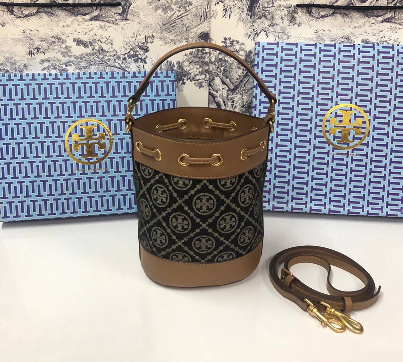 Mini : Tory Burch T Monogram Chenille Bucket Bag เปิดตัวอีกหนึ่งรุ่นกับกระเป๋าลาย T MONOGRAM รุ่นใหม่ล่าสุดจาก TORY BURCH พลาดไม่ได้กับโลโก้สุดคลาสสิก ลวดลาย T Monogram คือวัสดุ chenille หรือที่เรียกว่า ด้านไหมกำมะหยี่ มารังสรรค์ลงบนกระเป๋าBucketใบนี้ เป็
