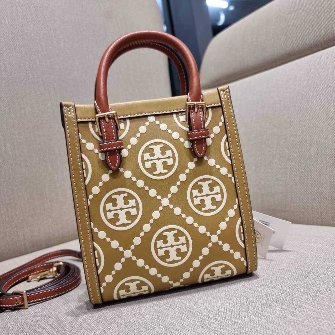 TORY BURCH T MONOGRAM EMBOSSED MINI TOTE สุดหรูกับกระเป๋าสะพายทรงโท้ท ไซส์มินิ ที่สร้างความหรูหราให้ตัวกระเป๋าด้วยดีเทลลายนูน แต่งแต้มลวดลายเอกลักษณ์ สีลูกคุณมากๆ!! วัสดุหนังแท้ ผิวสัมผัสดี ปากกระเป๋ามีแถบแม่เหล็กกันของหล่นได้ ภายในโล่ง ใส่ของจำเป็นได้ โท