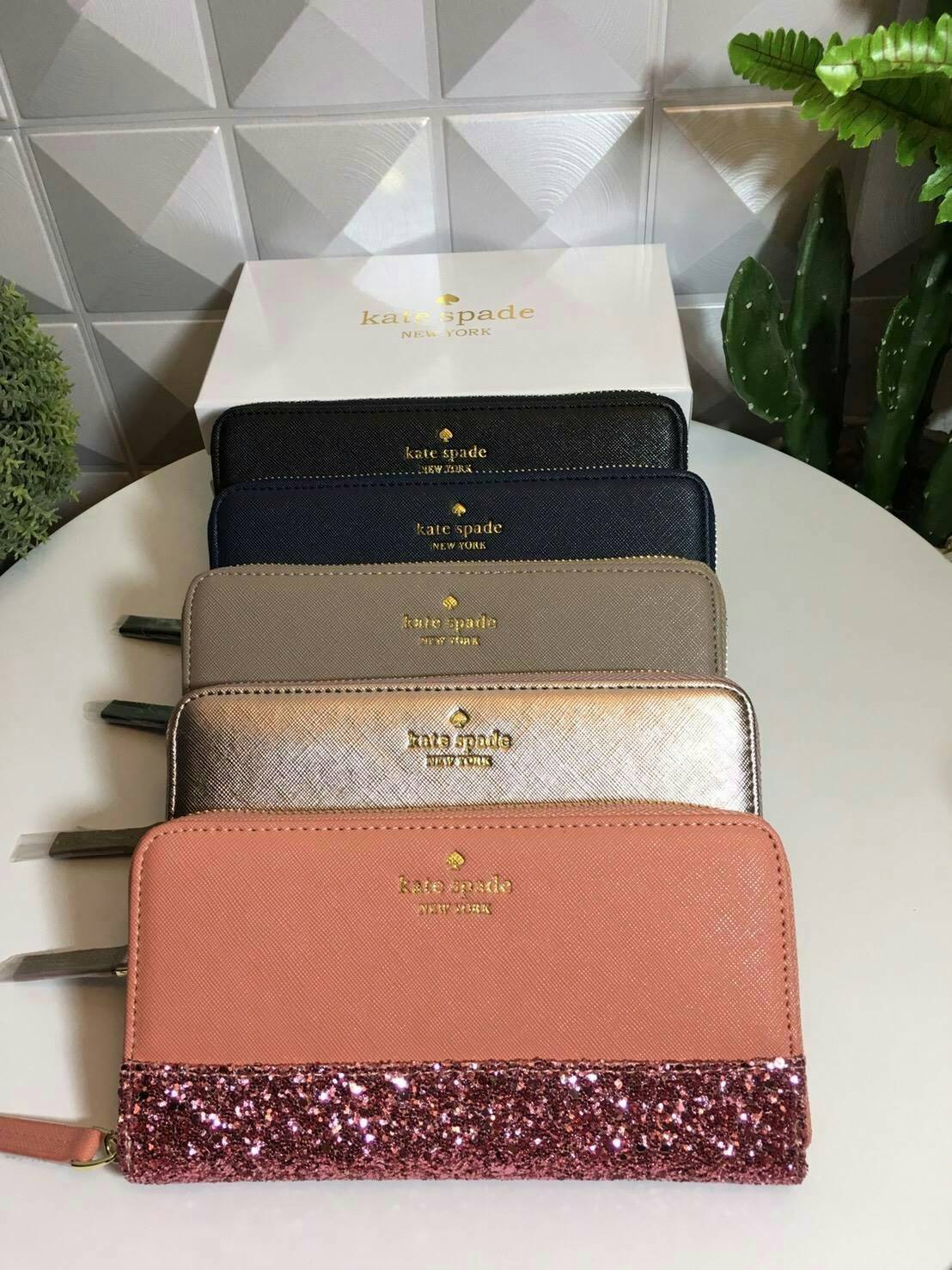 KATE SPADE LONG WALLET กระเป๋าสตางค์ใบยาวรุ่นใหม่ล่าสุดหนัง Saffiano สไตล์ PRADA สวยน่าใช้ตัวกระเป๋าตกแต่งด้วยกลิทเตอร์ ภายในมีช่องซิป1ช่อง และช่องใส่บัตรหลายช่อง ใส่เหรียญ บัตรได้เยอะ ตัวจริงสวยน่าใช้มากค่ะ