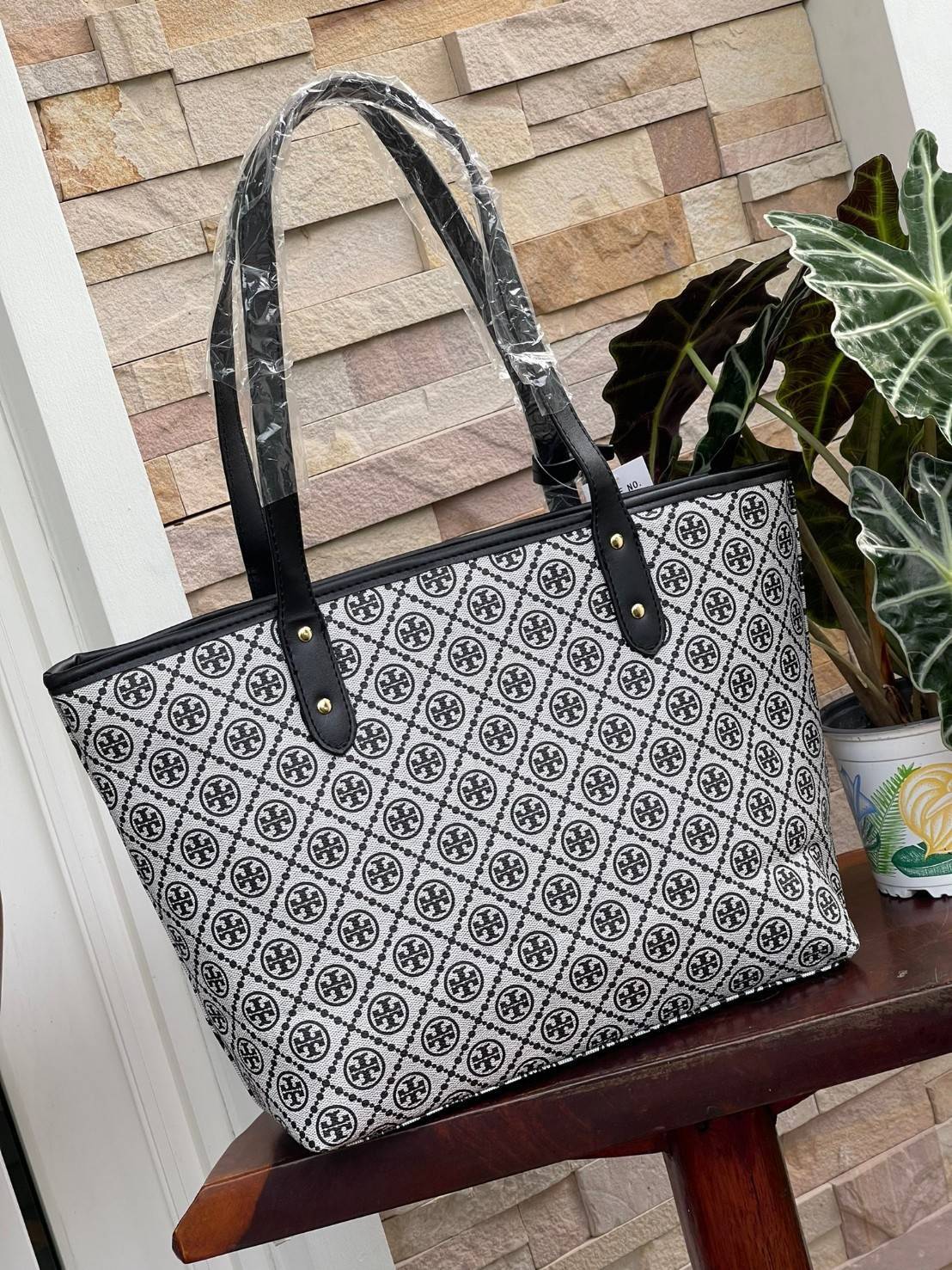 OUTLET 】Tory burch T Monograme Large shopping bag กระเป๋าสะพายใบไหล่ใบใหญ่ โดยตัวกระเป๋าทำมาจากผ้าแคนวาสเคลือบผิวด้านทนต่อรอยขีดข่วนได้เป็นอย่างดี ขนาดที่ใหญ่สามารถใส่ได้ทั้งเอกสารและสัมภาระต่างๆ พร้อมด้วยซิปปิดกระเป๋าด้านบนจึงเป็นอีกรุ่นที่เหมาะกับสาวออฟ