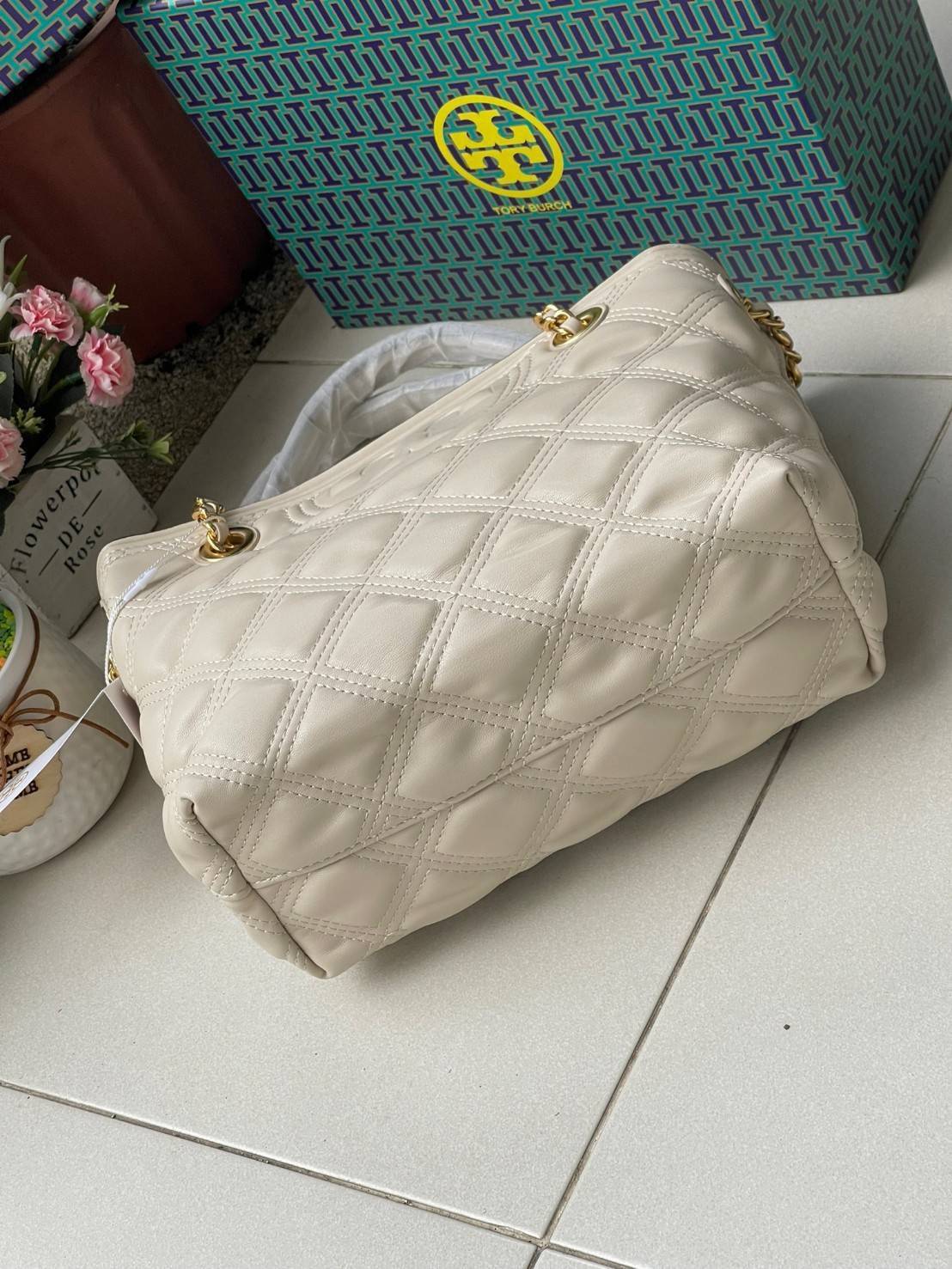 Tory Burch Fleming Soft Small Tote Bag เป็นกระเป๋าสะพายไหล่น่ารัก ๆ สักใบที่มีดีไซน์โดดเด่น สะดุดตา ใน Collection เรียกได้ว่าขายดีอันดับต้น ๆ ของแบรนด์ ใช้ได้ในลุคช์ทางการและกึ่งทางการ ดีเทลการตัดเย็บพิมพ์ลายนูนคู่กับแพทเทิร์นสี่เหลี่ยมทรงเพชร ที่ช่วยเพิ่